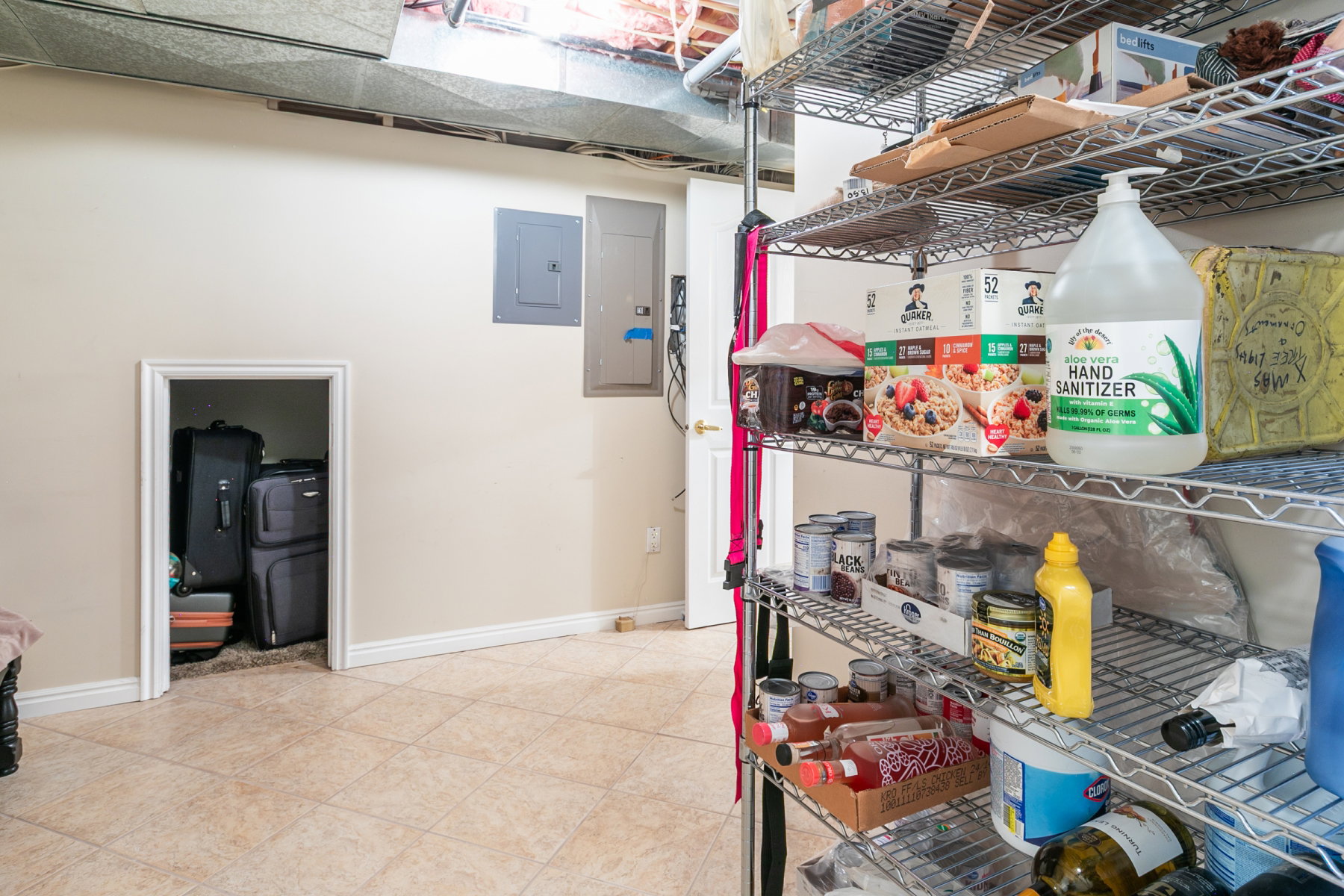 Utility area featuring tiled flooring, a built-in storage alcove, and exposed ductwork
