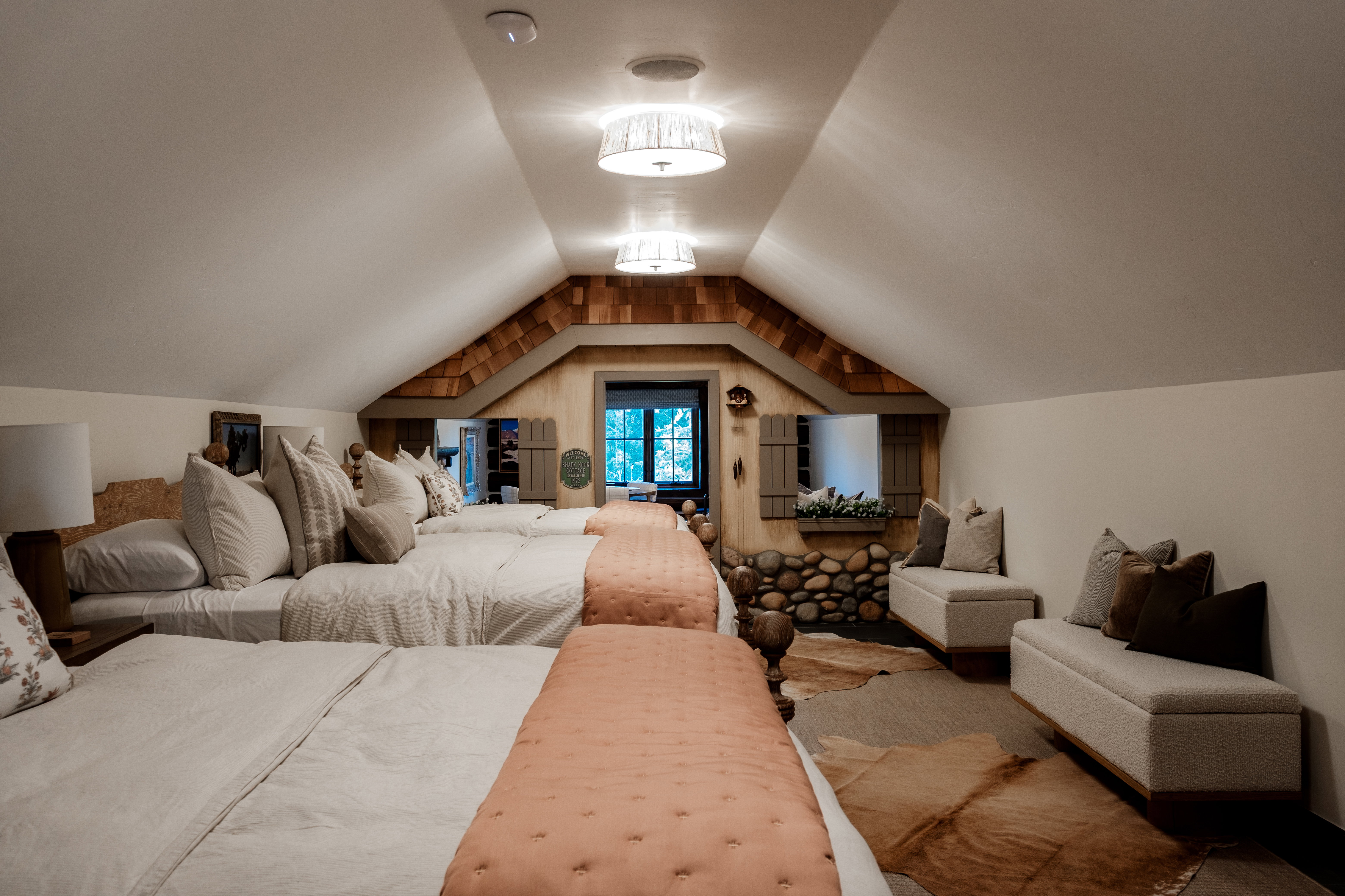 Sloped ceiling room featuring recessed lighting, a window with exterior shutters, a stone-finish wall detail, and built-in upholstered benches