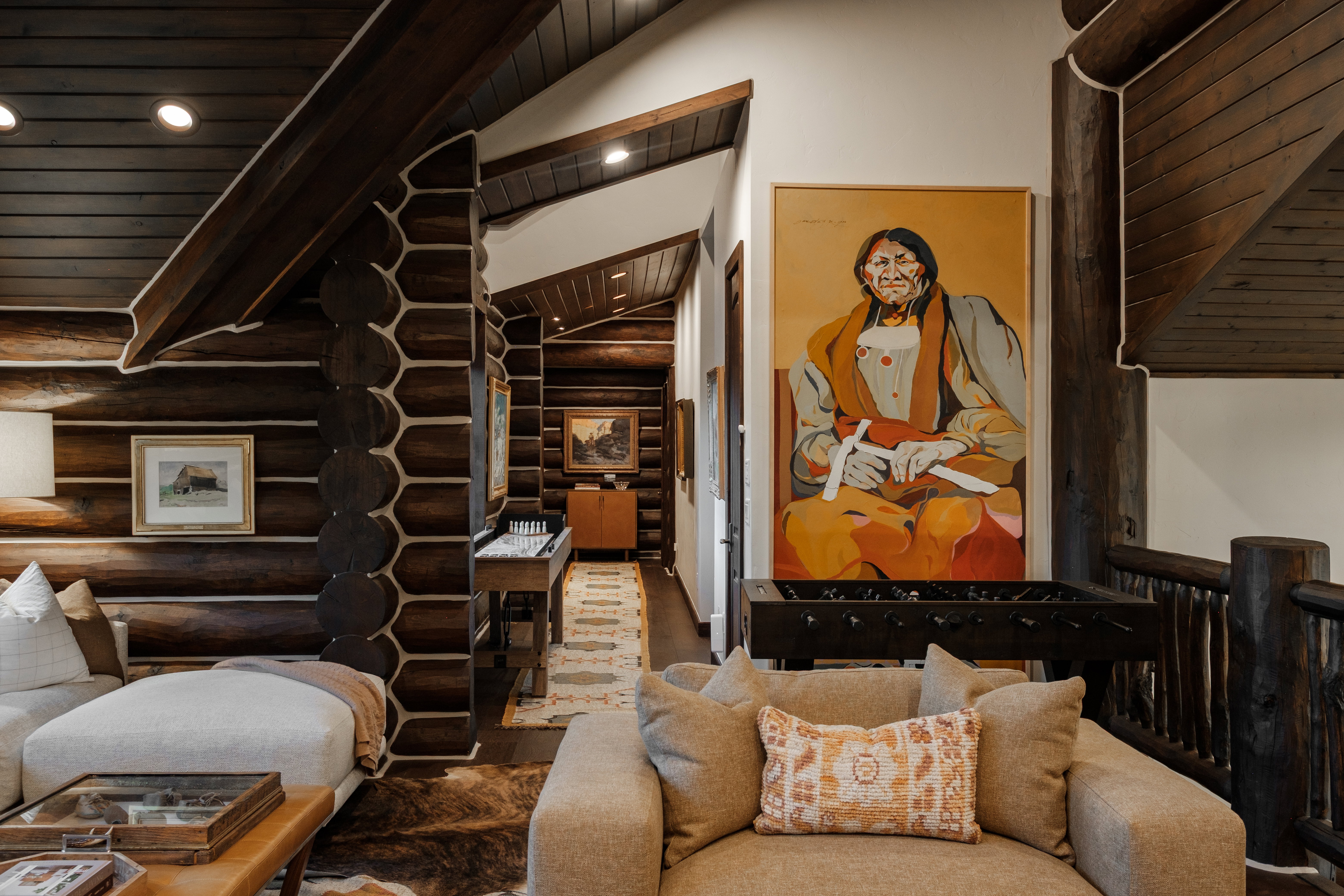 Log home interior featuring exposed log walls, coffered wood ceilings, and recessed lighting