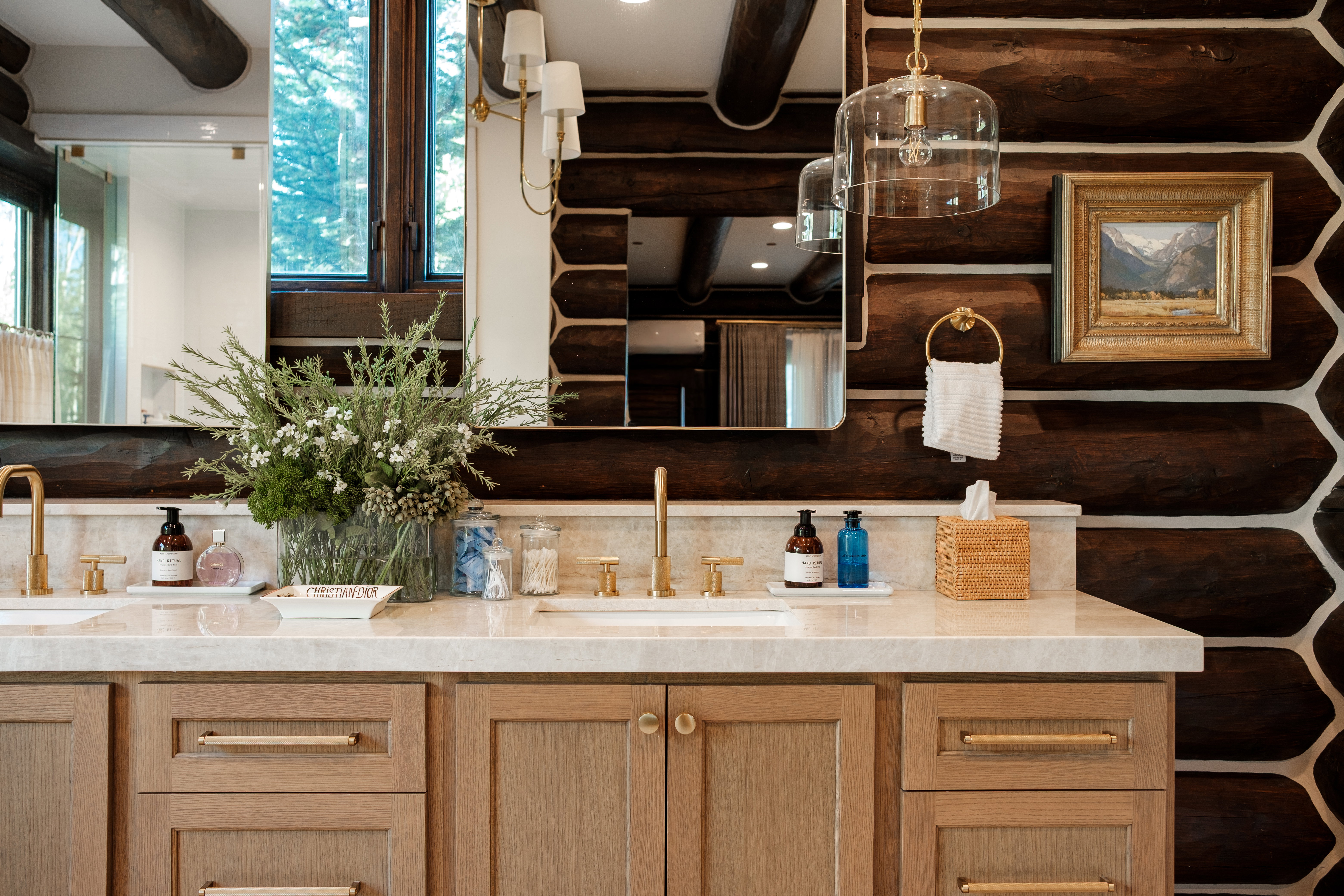 Dual undermount sinks with gold-toned fixtures complement the light-toned countertop
