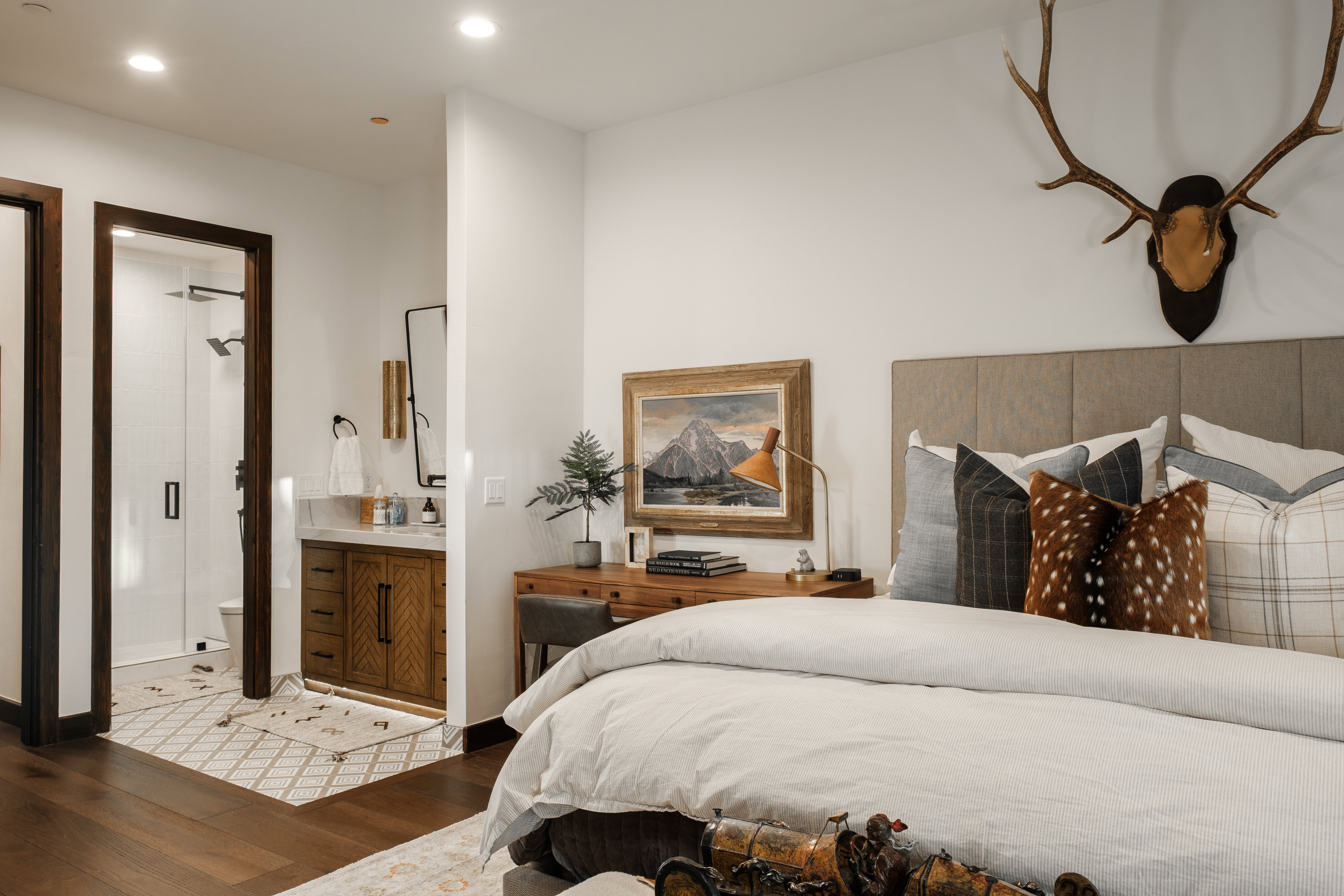 Bedroom featuring rich wood-finish flooring, a plush upholstered headboard, and recessed lighting
