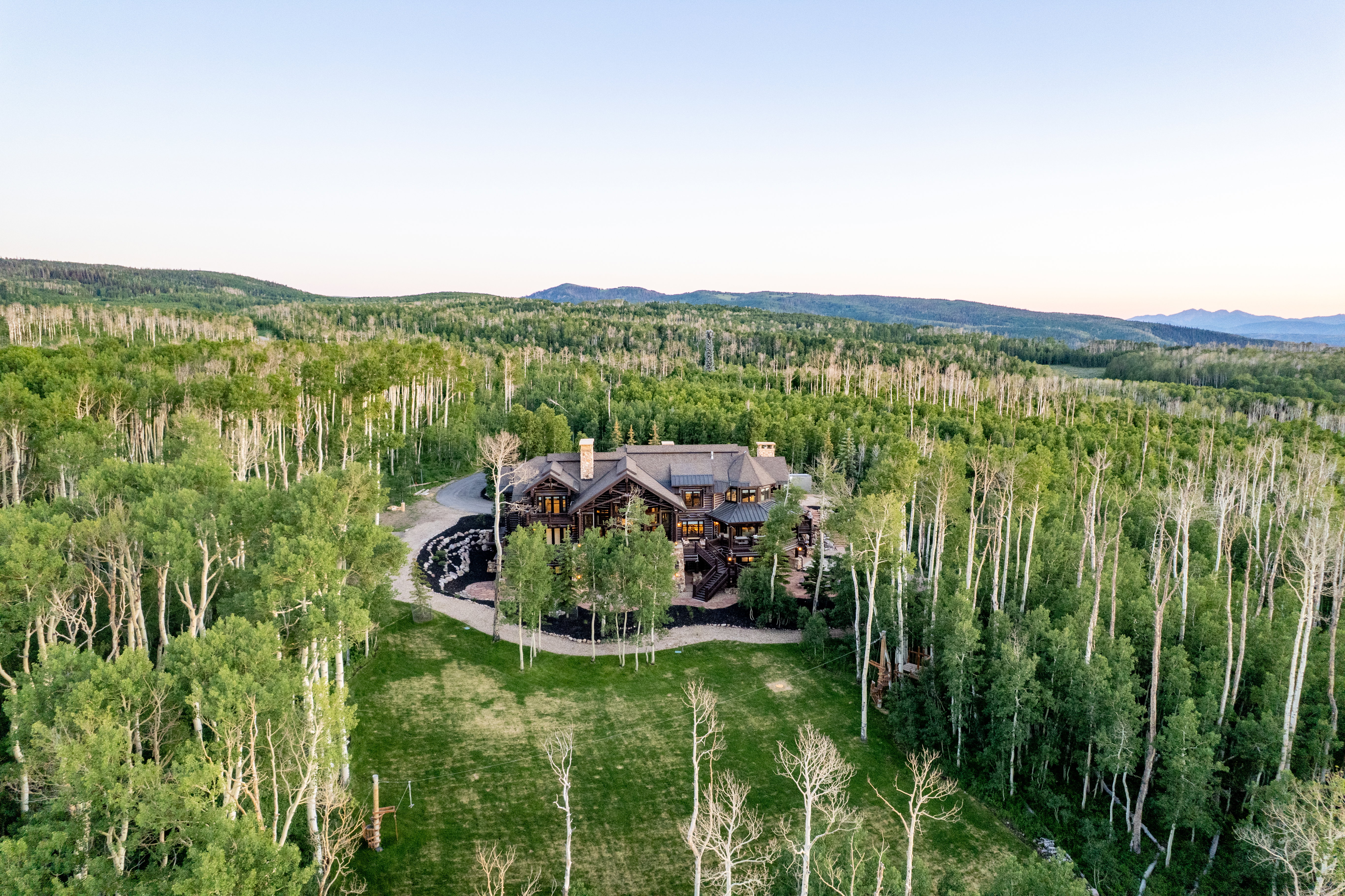 Expansive wooded property featuring a substantial residence with multiple gables and dormers