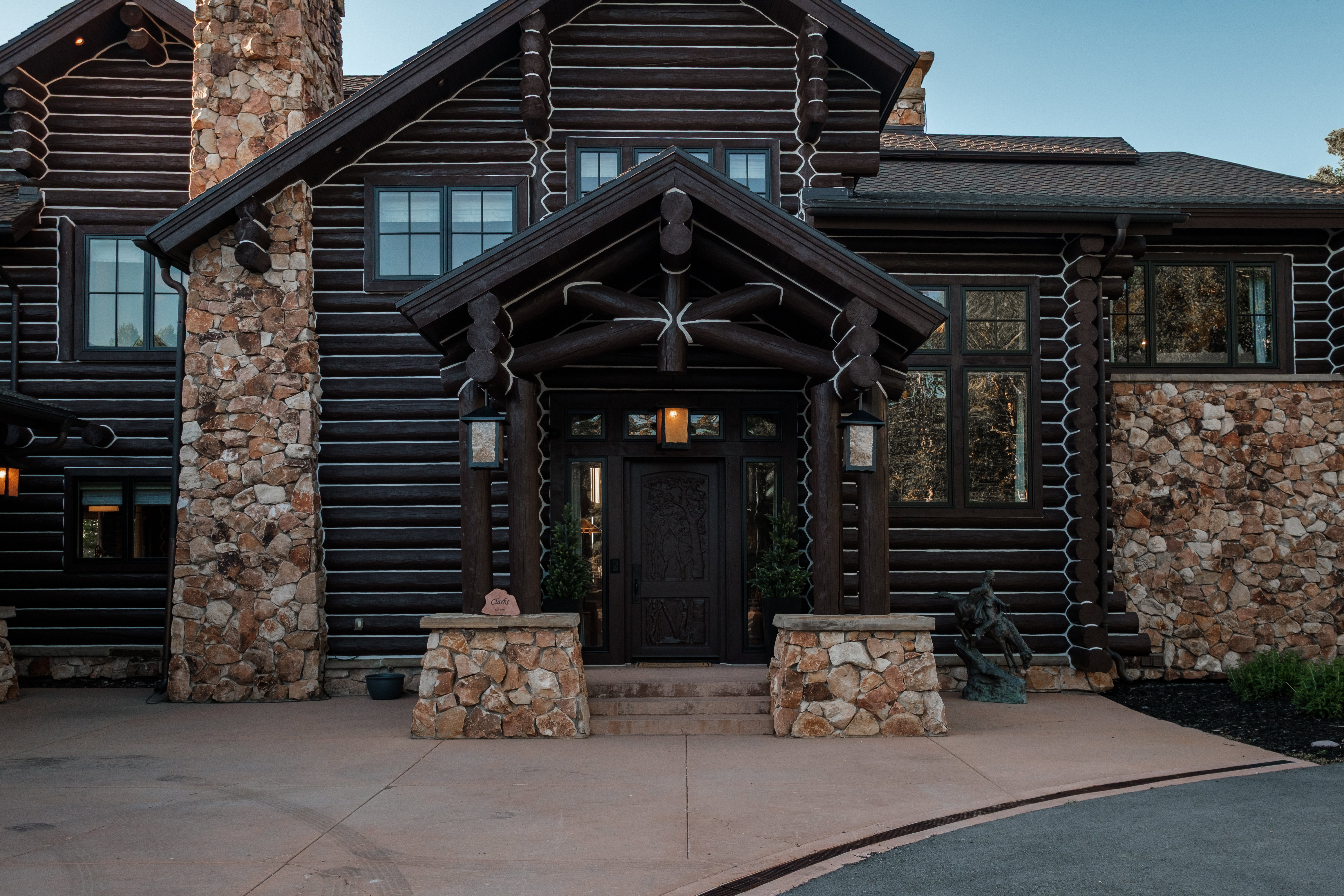 Log-style home featuring a stone facade and chimney accents