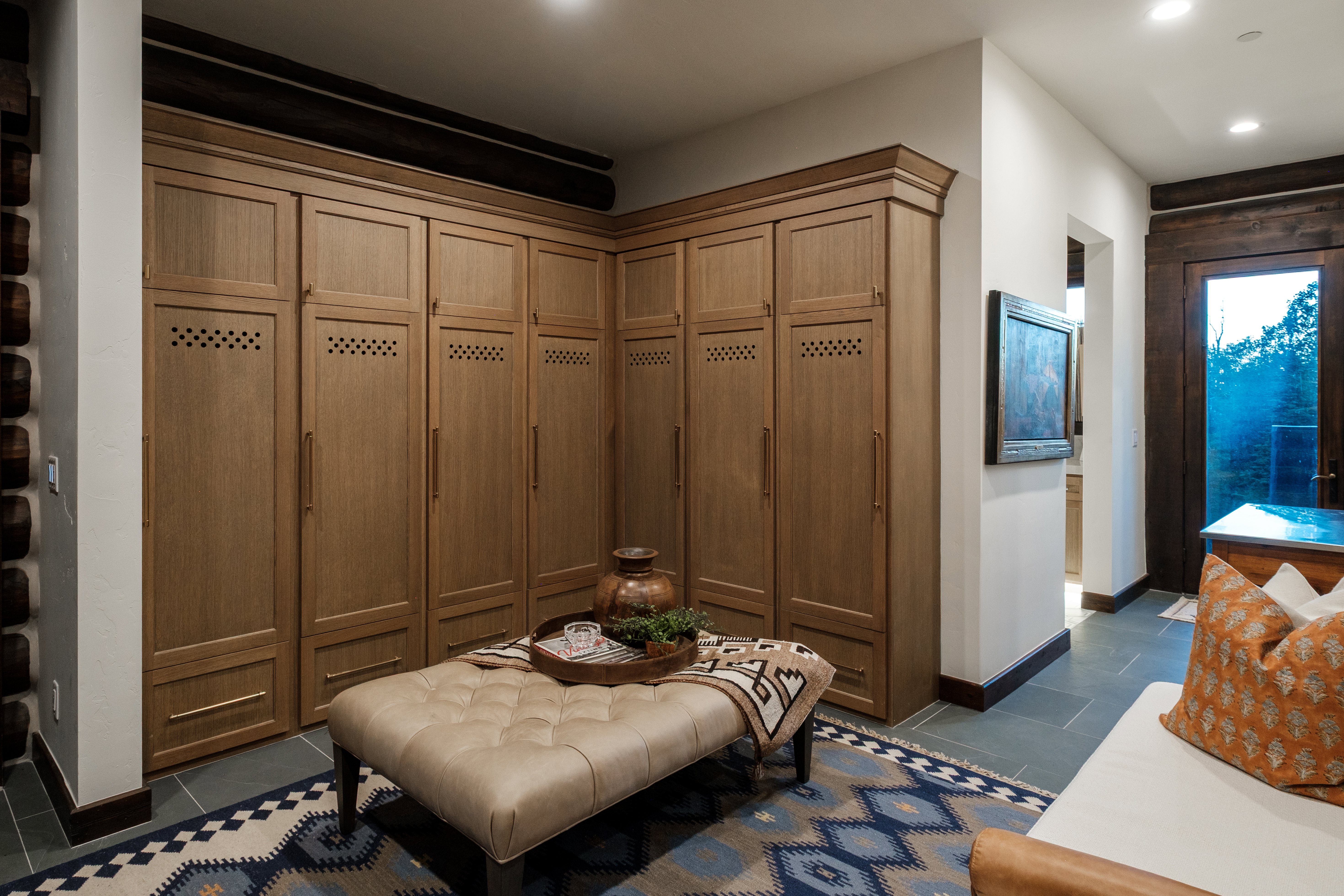 Built-in wood-finish cabinetry featuring ventilated panels and crown molding