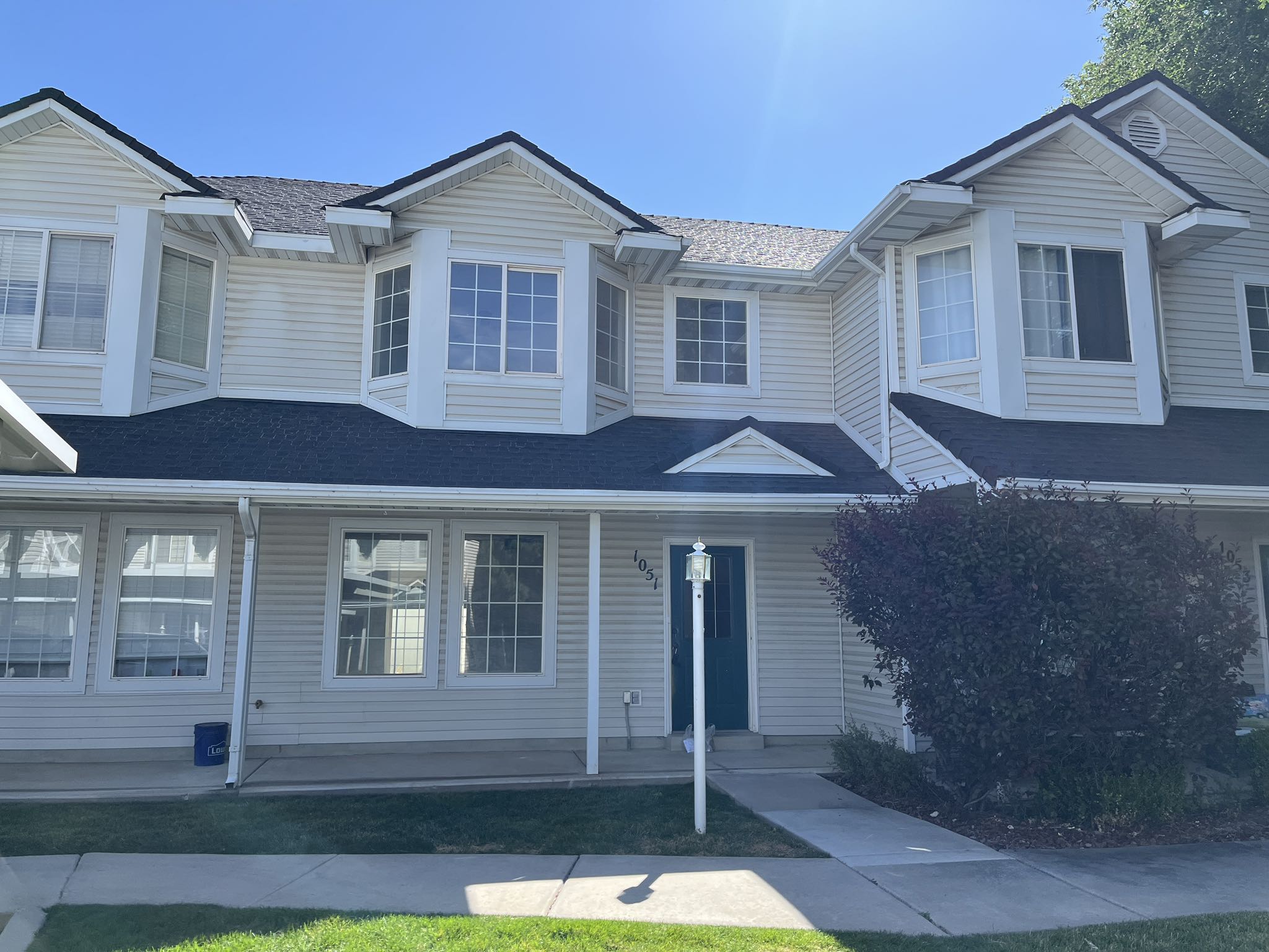 Exterior with light-toned horizontal siding and dark roofing