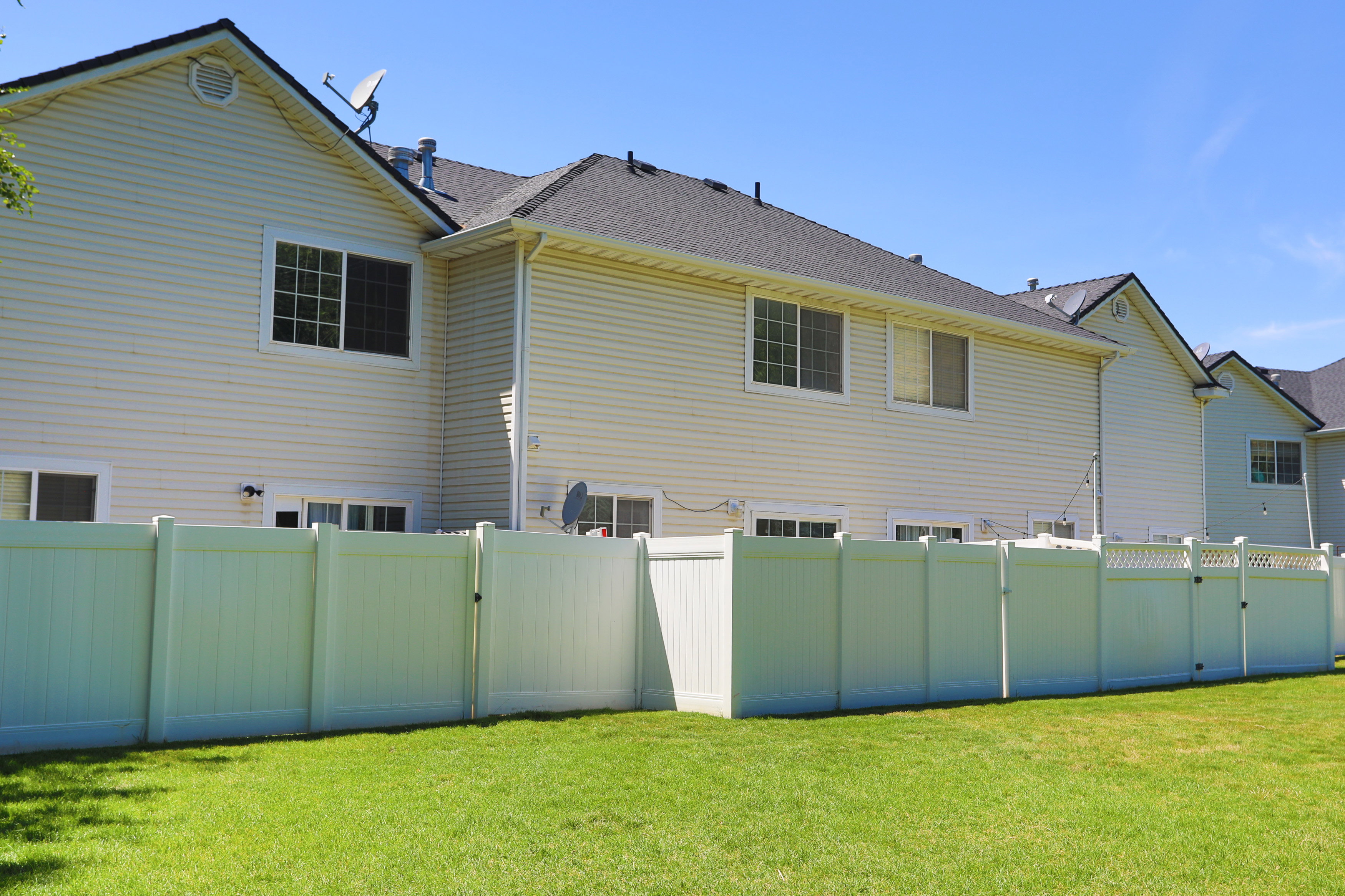Spacious lawn area featuring a full-height privacy fence