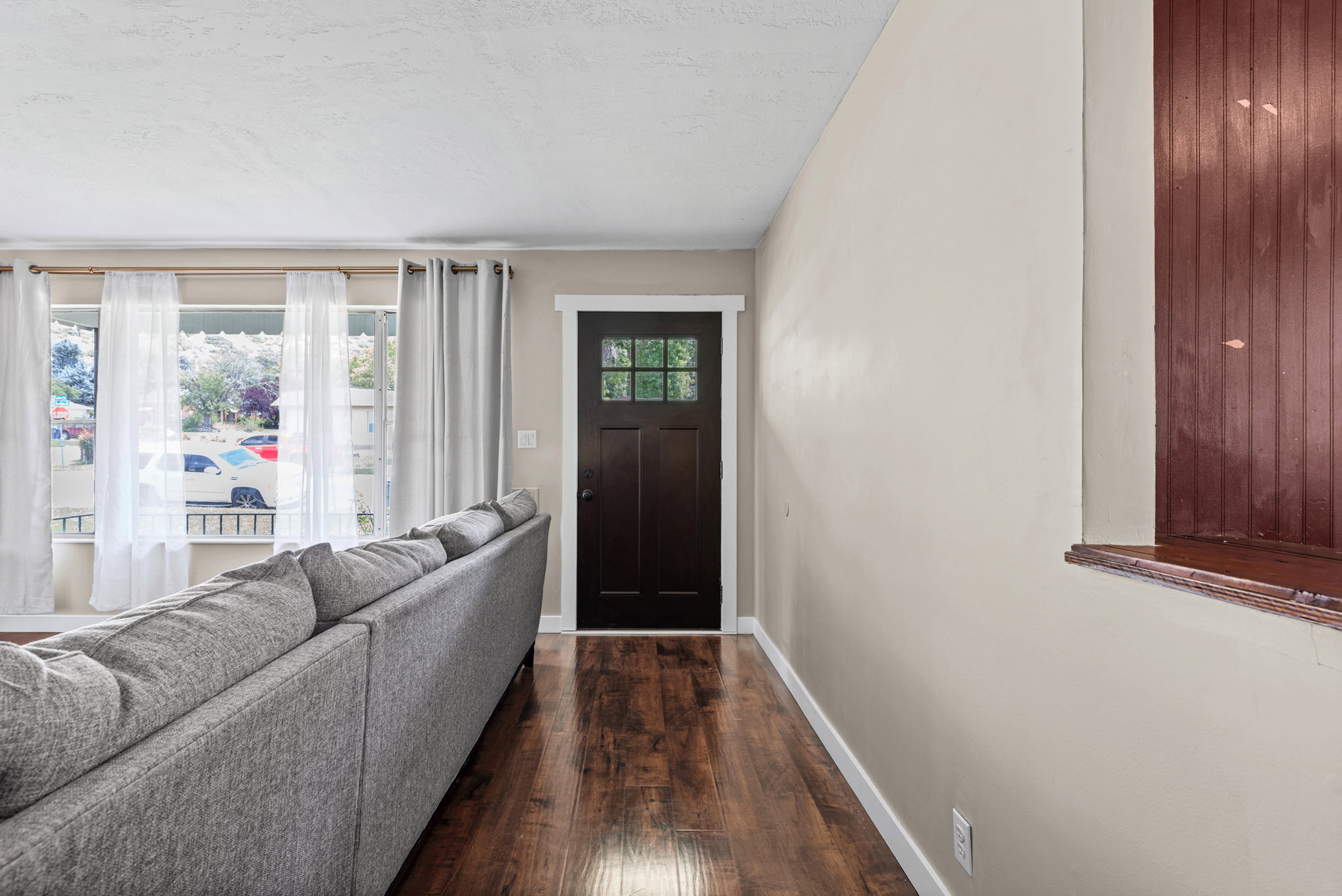 Entry area featuring a dark wood-finish door with glass inserts, wood-finish flooring, and light-toned walls