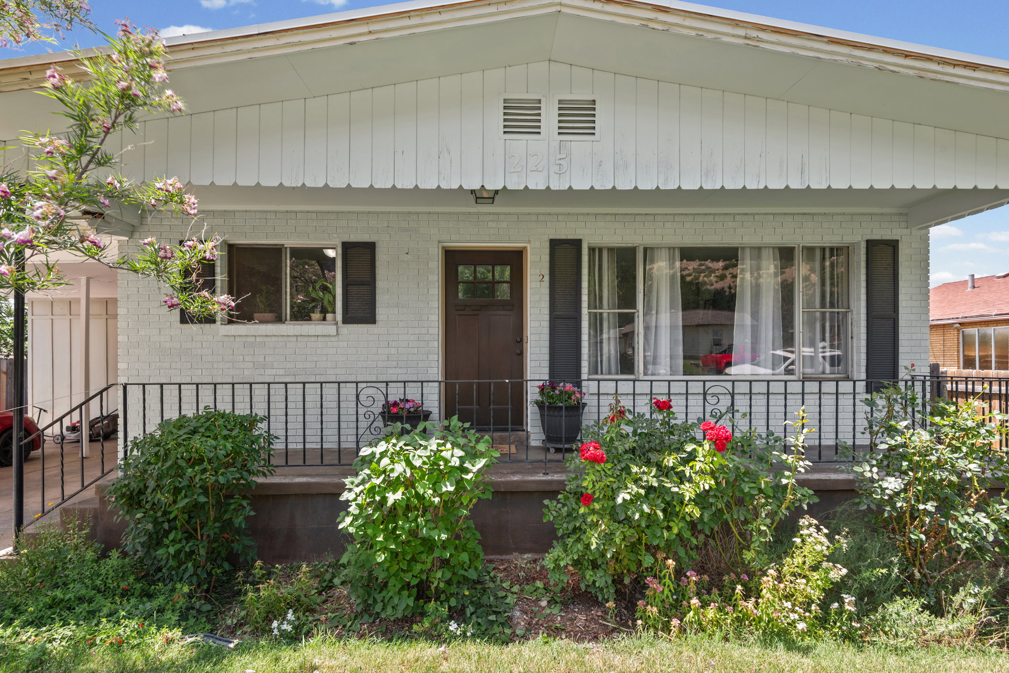 Brick facade with white paint, dark wood entry door, and a covered porch