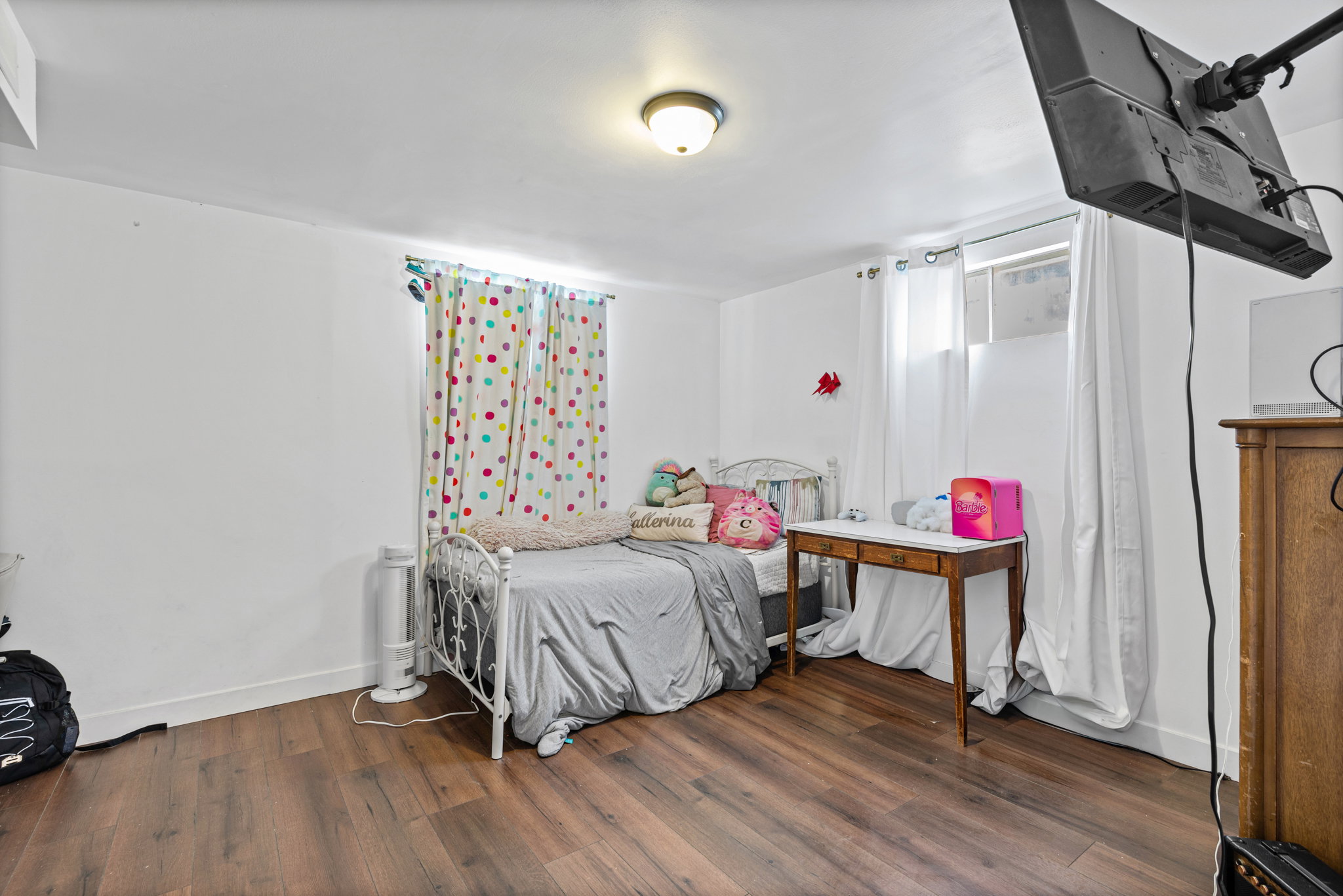Room featuring wood-finish flooring, white walls, and a ceiling-mounted light fixture