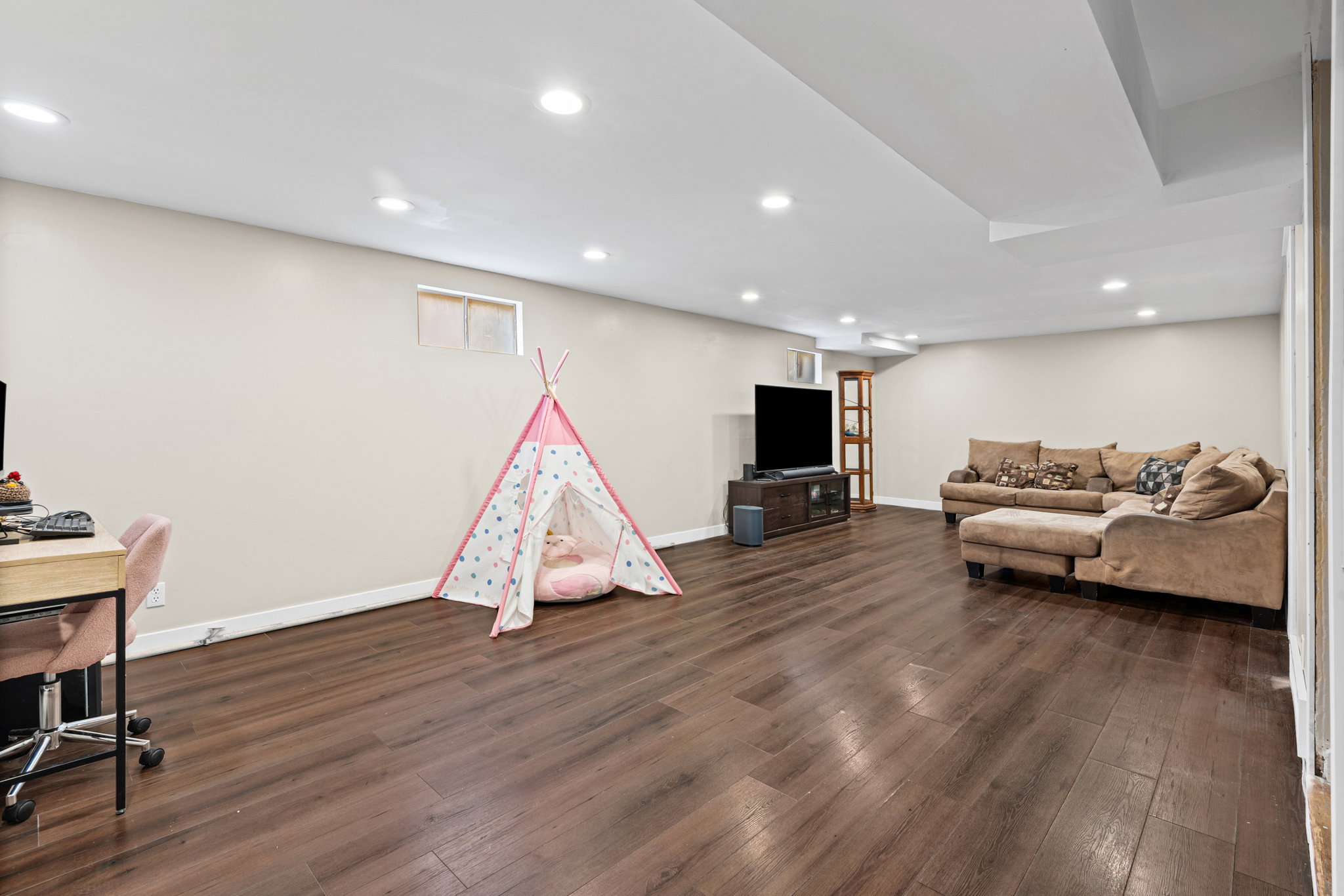 Spacious room featuring wood-finish flooring, recessed lighting, and neutral wall tones