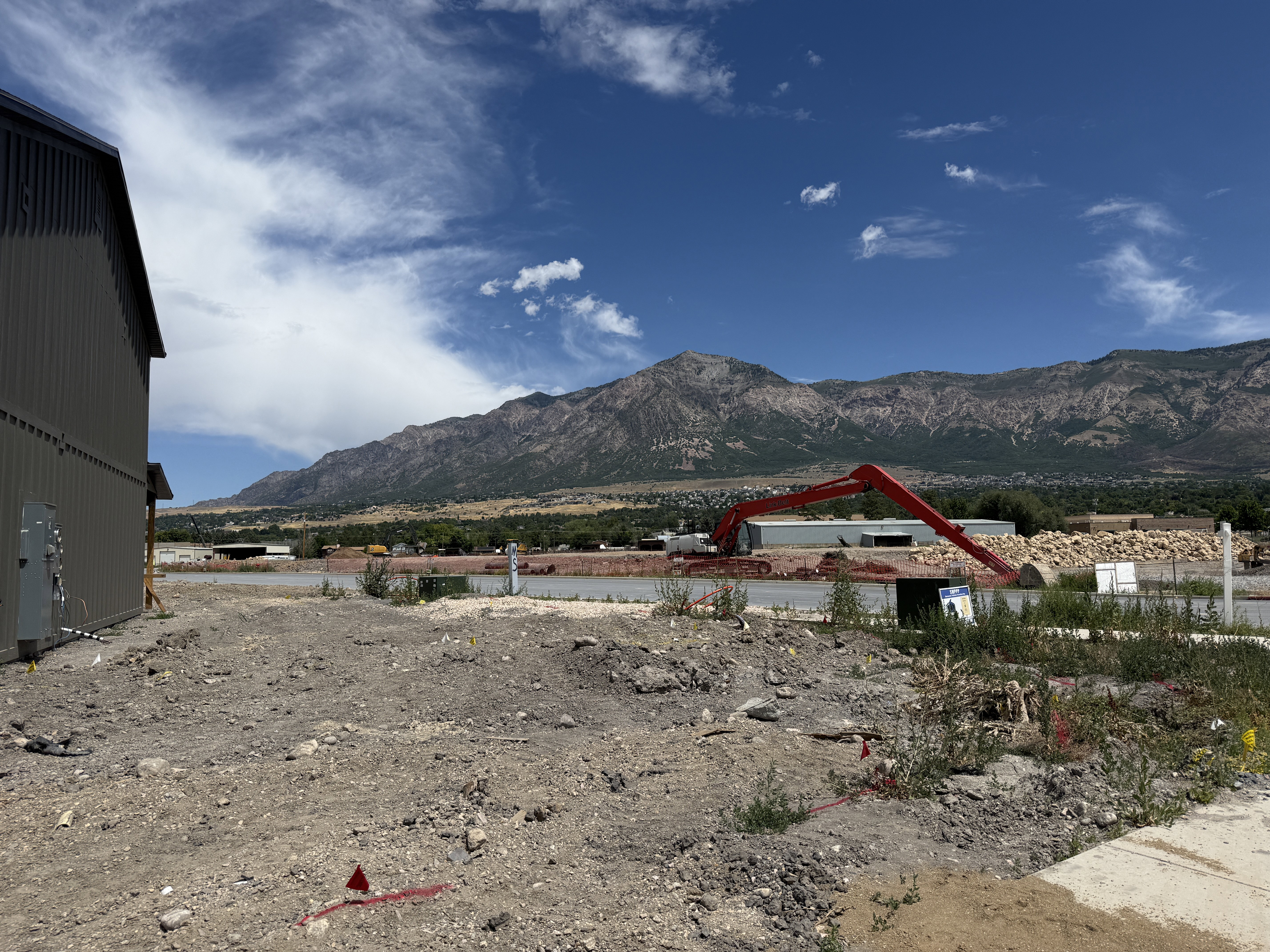 Expansive land offering a clear mountain backdrop, partially developed with visible utility infrastructure