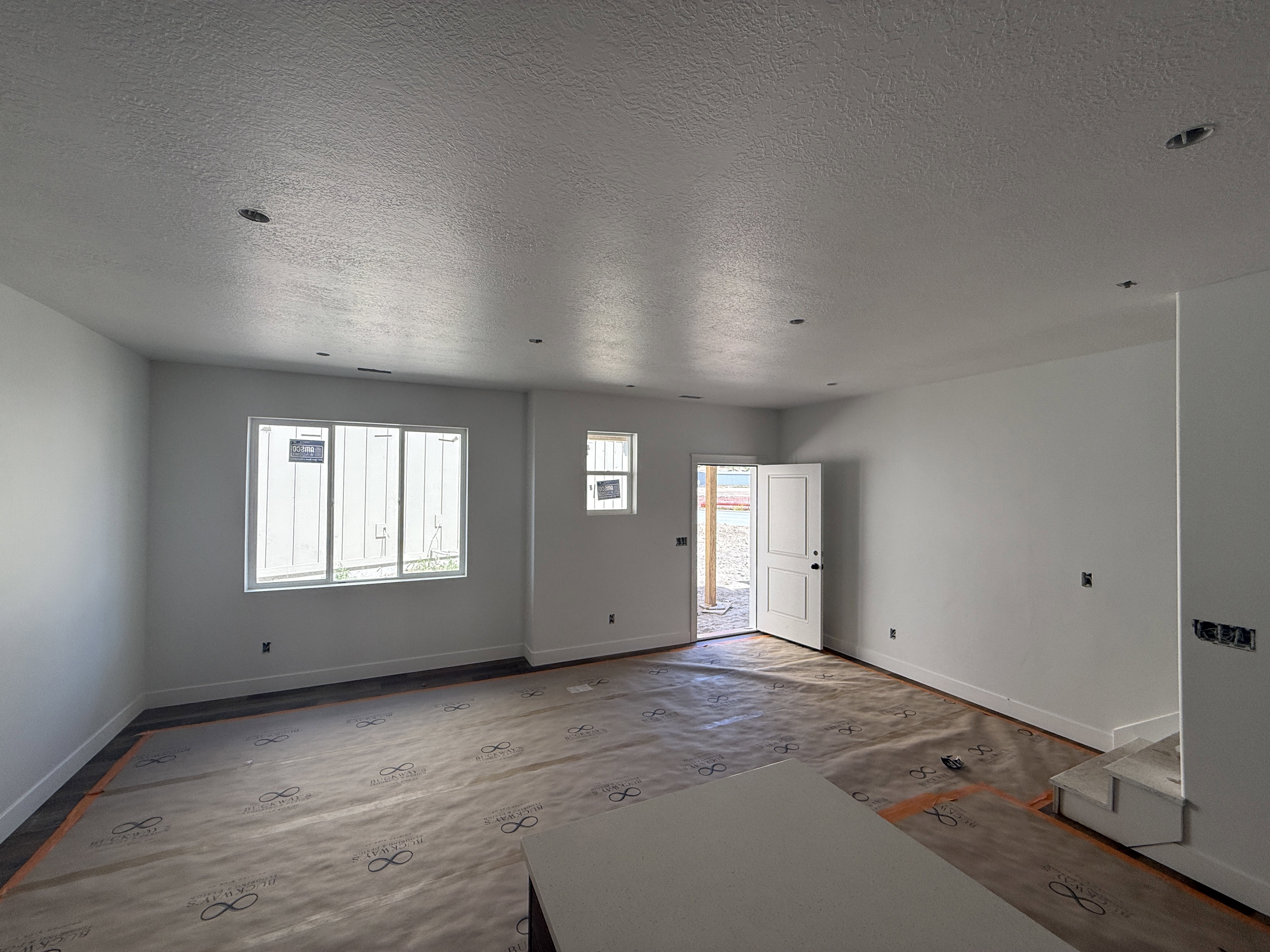 Spacious interior featuring multiple windows, recessed lighting, and a white paneled door