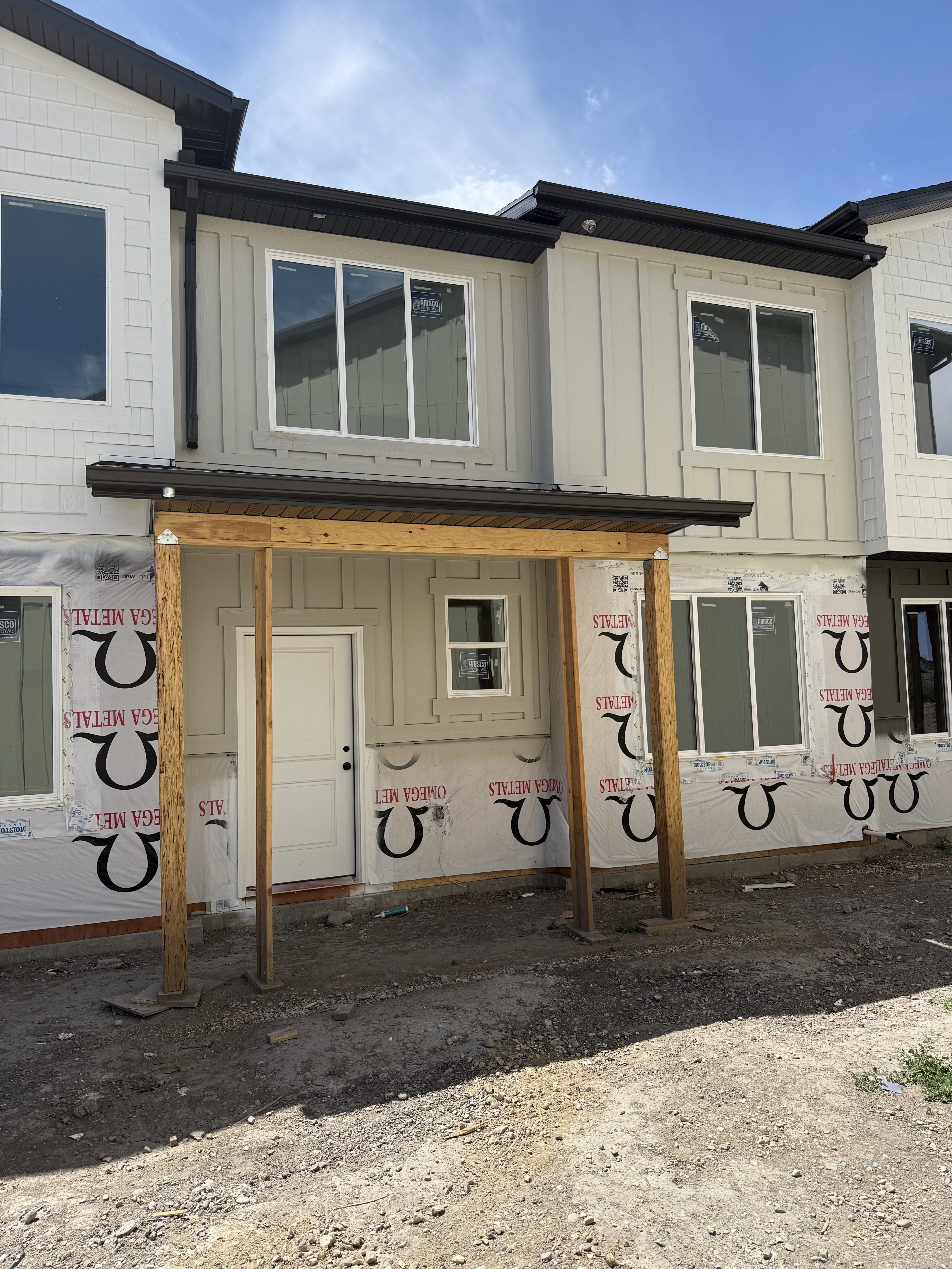 Contemporary multi-level exterior with board and batten siding, horizontal siding accents, dark brown gutters, and white frame windows