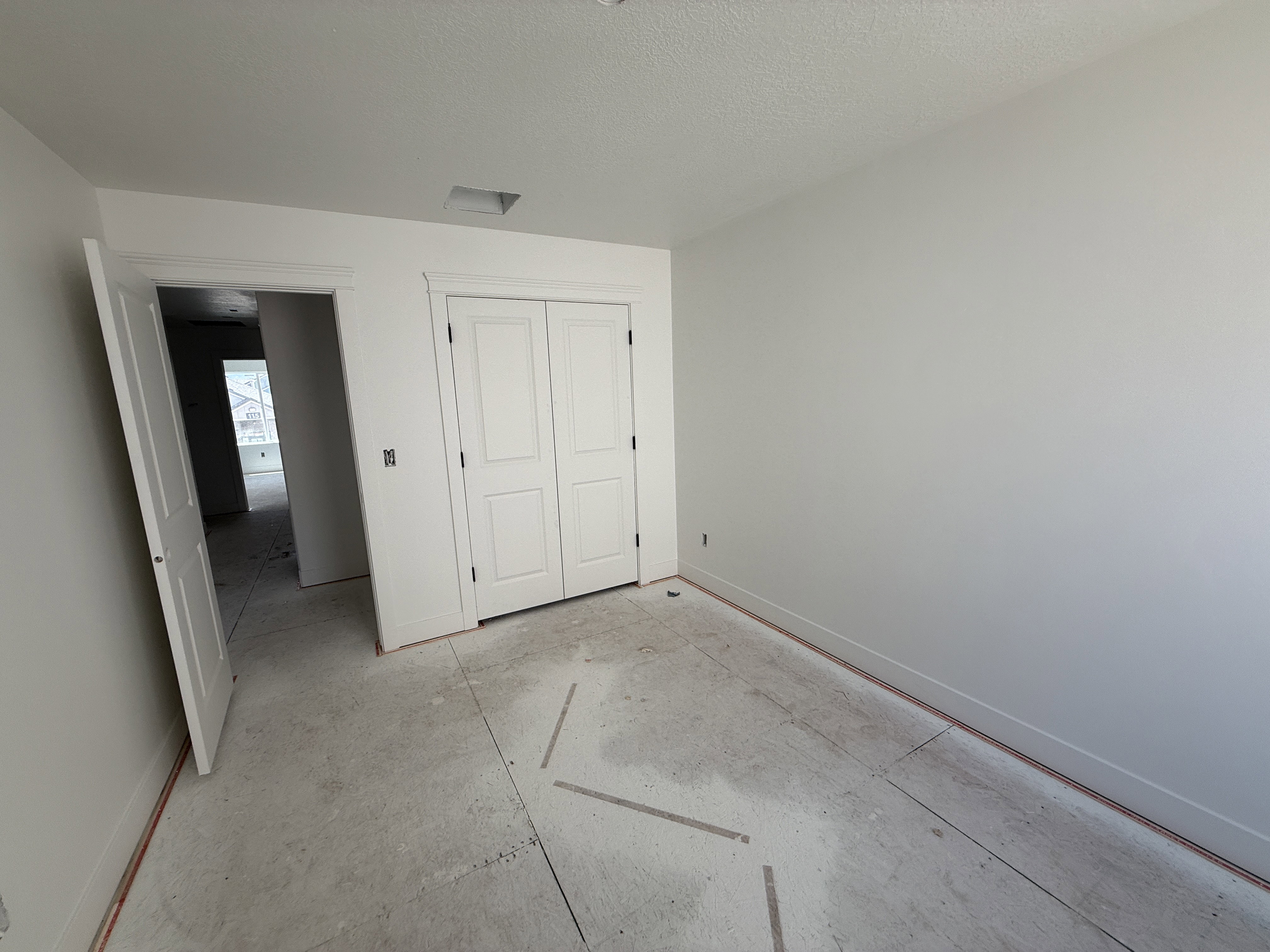 Neutral wall paint with tall baseboards, white paneled doors, and a built-in closet