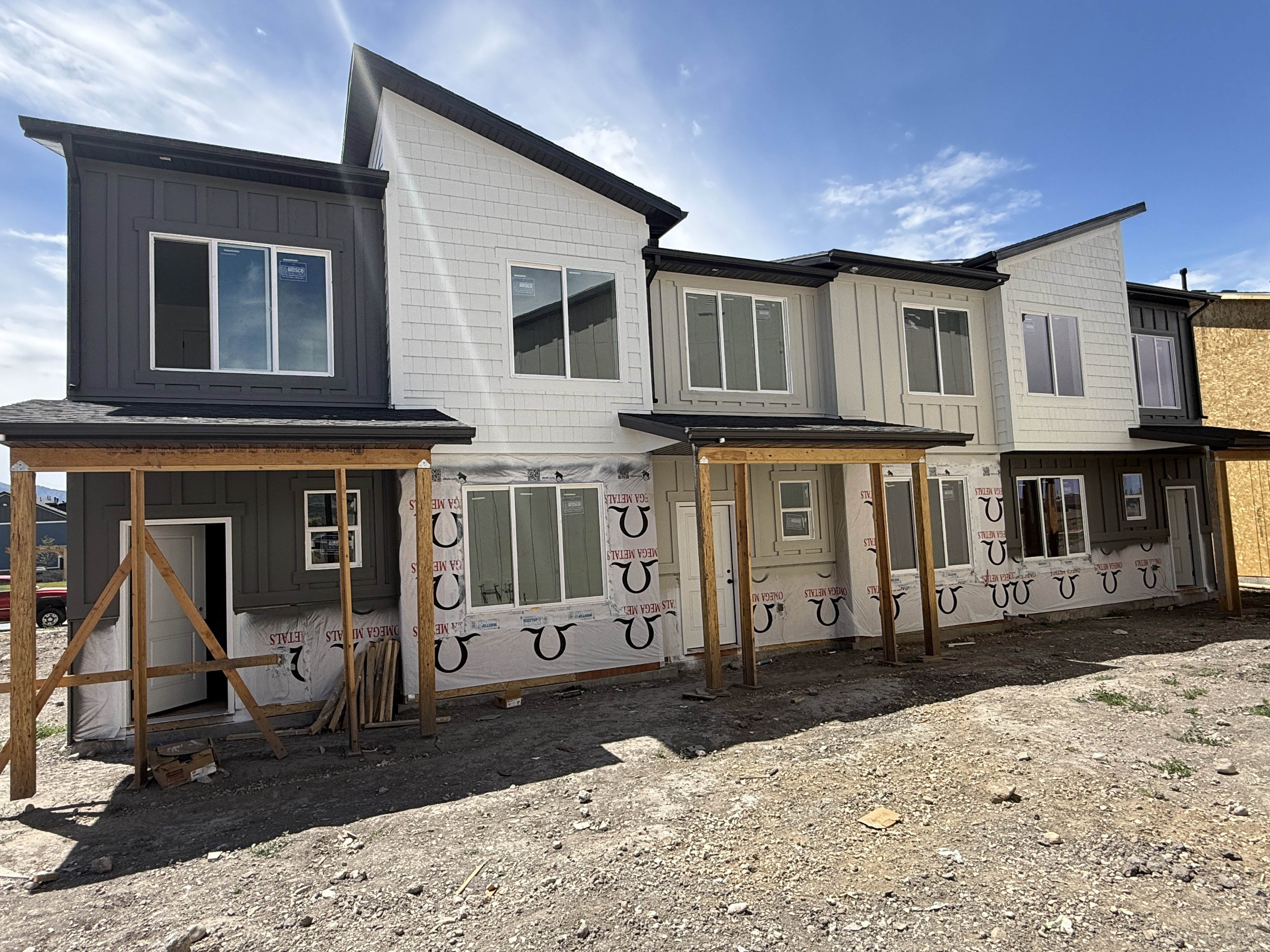Modern multi-level townhome exteriors featuring varied siding textures and a monochromatic color palette