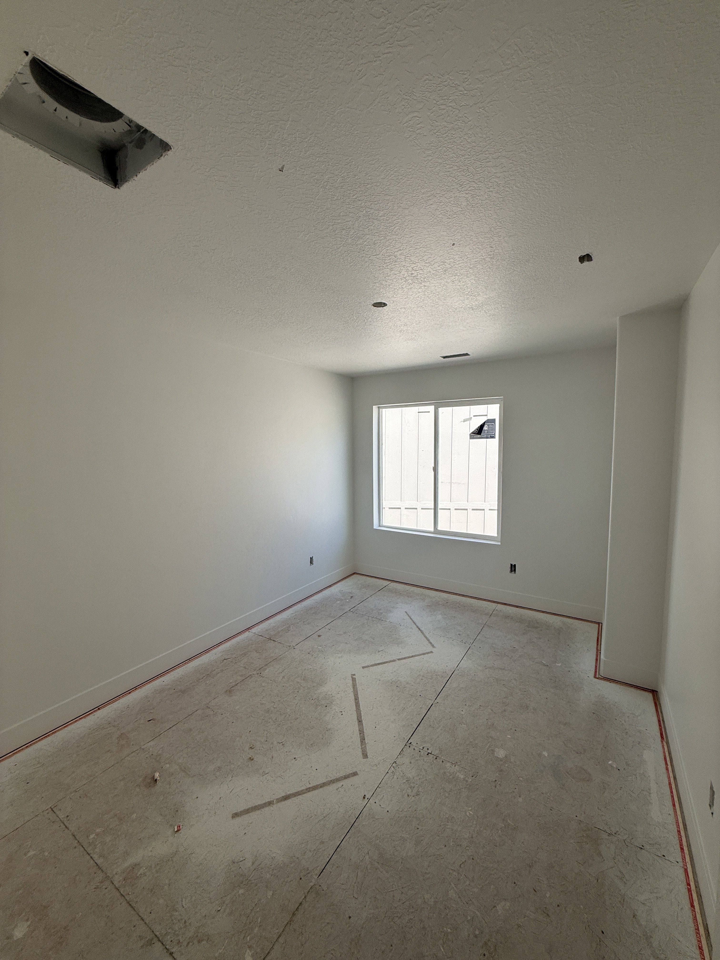 Room with neutral wall paint and a single window