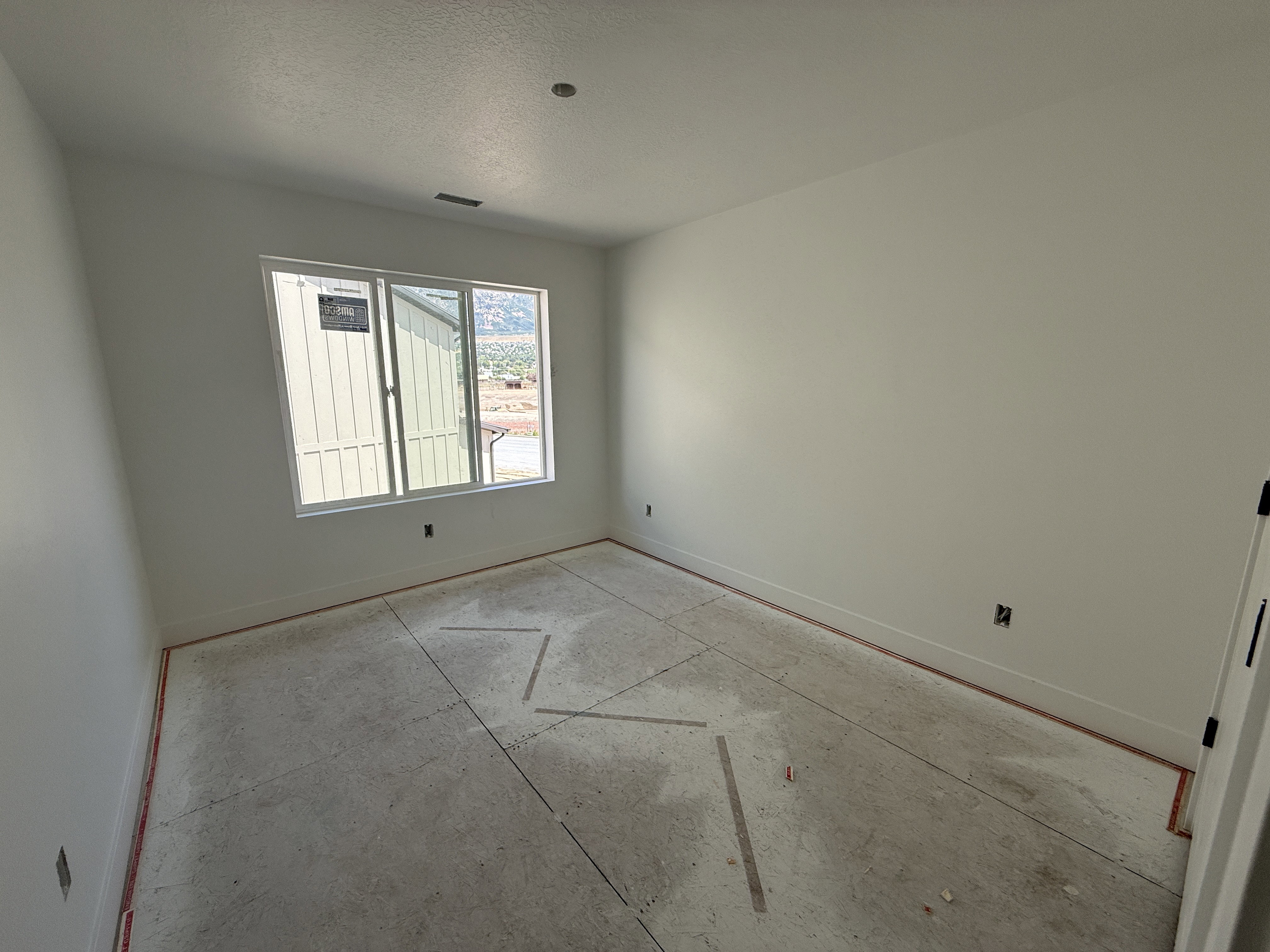Spacious room featuring a large window, recessed lighting, and white baseboards