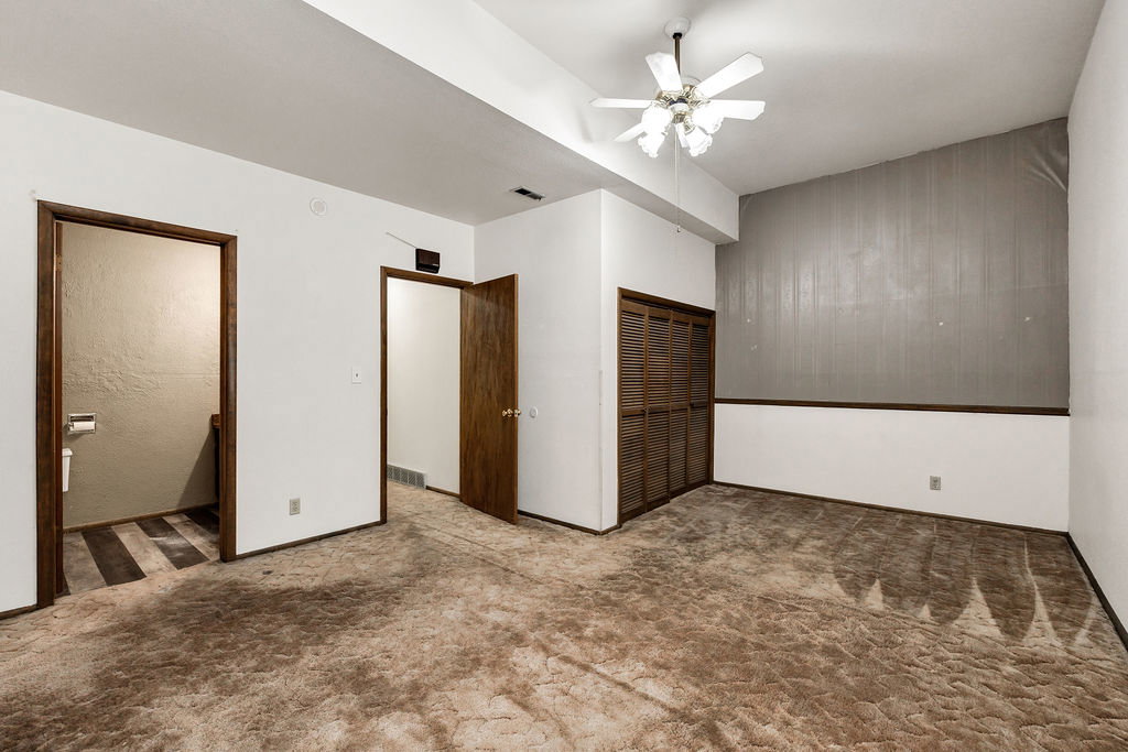 Room featuring a slatted bi-fold closet, ceiling fan, and two interior doorways