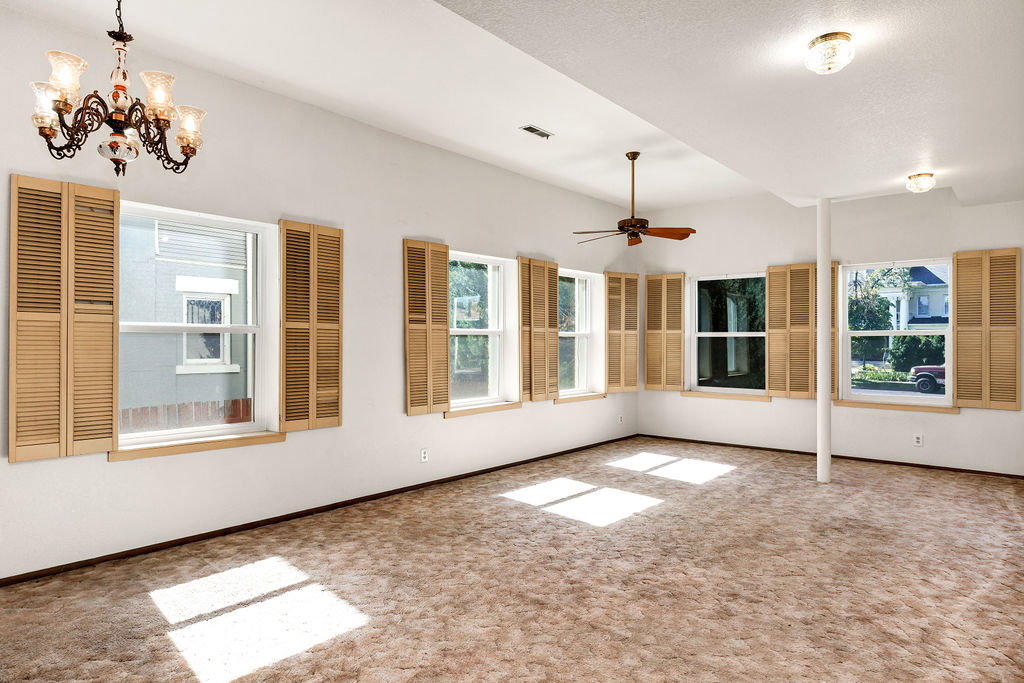 Spacious room with multiple windows featuring wood-tone plantation shutters