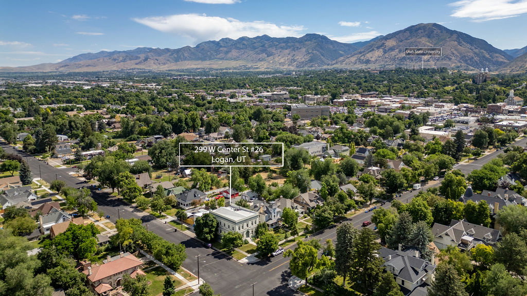 Aerial perspective showcasing a community setting with extensive tree canopies and mountainous terrain