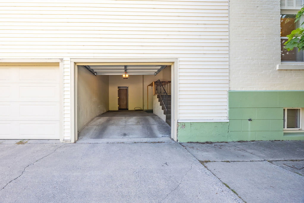 Two-car garage featuring a roll-up door, interior lighting, and a concrete driveway