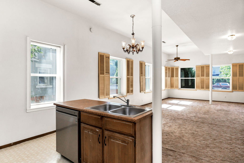 Kitchenette area featuring a stainless steel dishwasher, double basin sink, and wood cabinetry