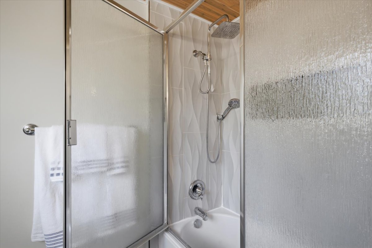 Shower-over-tub combination with textured glass enclosure and chrome hardware