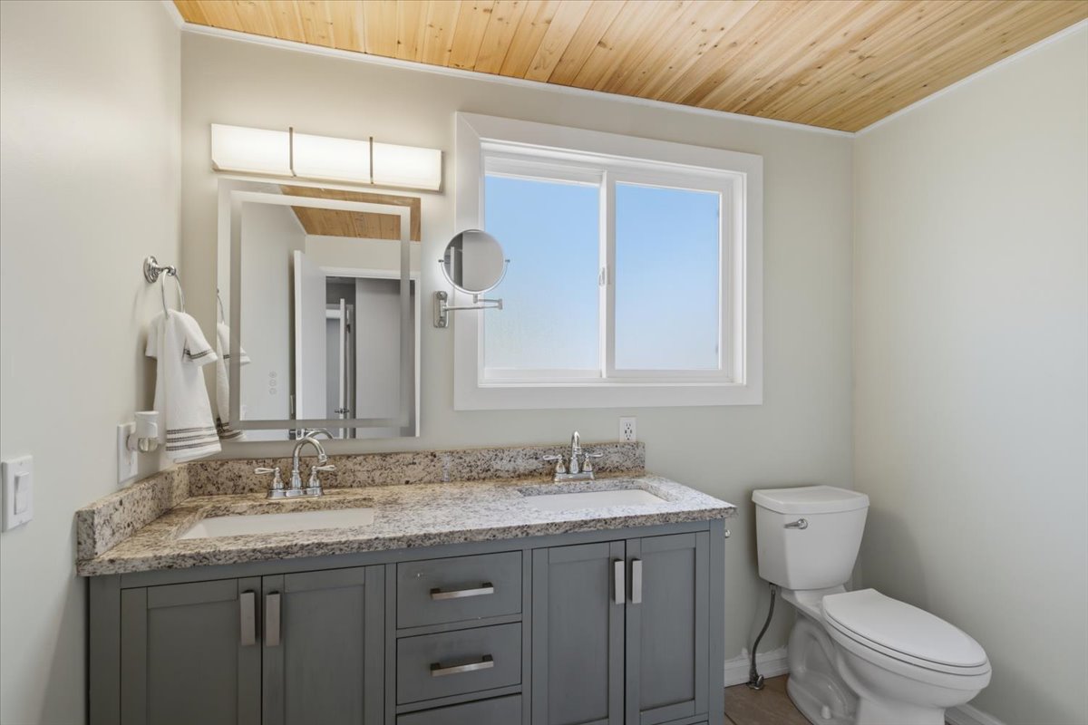Dual vanity featuring a light granite-style countertop, undermount sinks, and chrome faucets