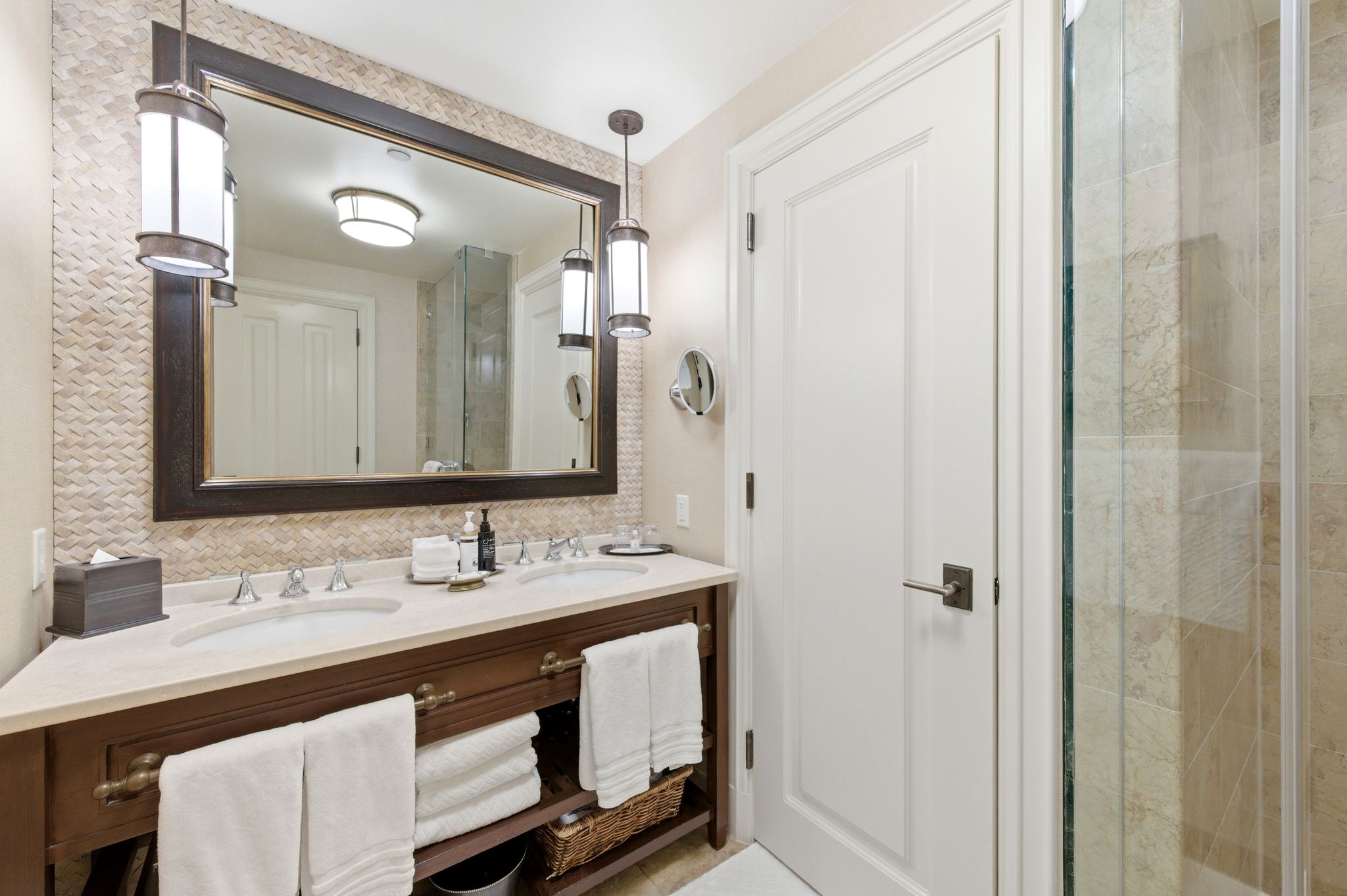 Bathroom featuring a double vanity with stone countertop, dual undermount sinks, and dark wood cabinetry