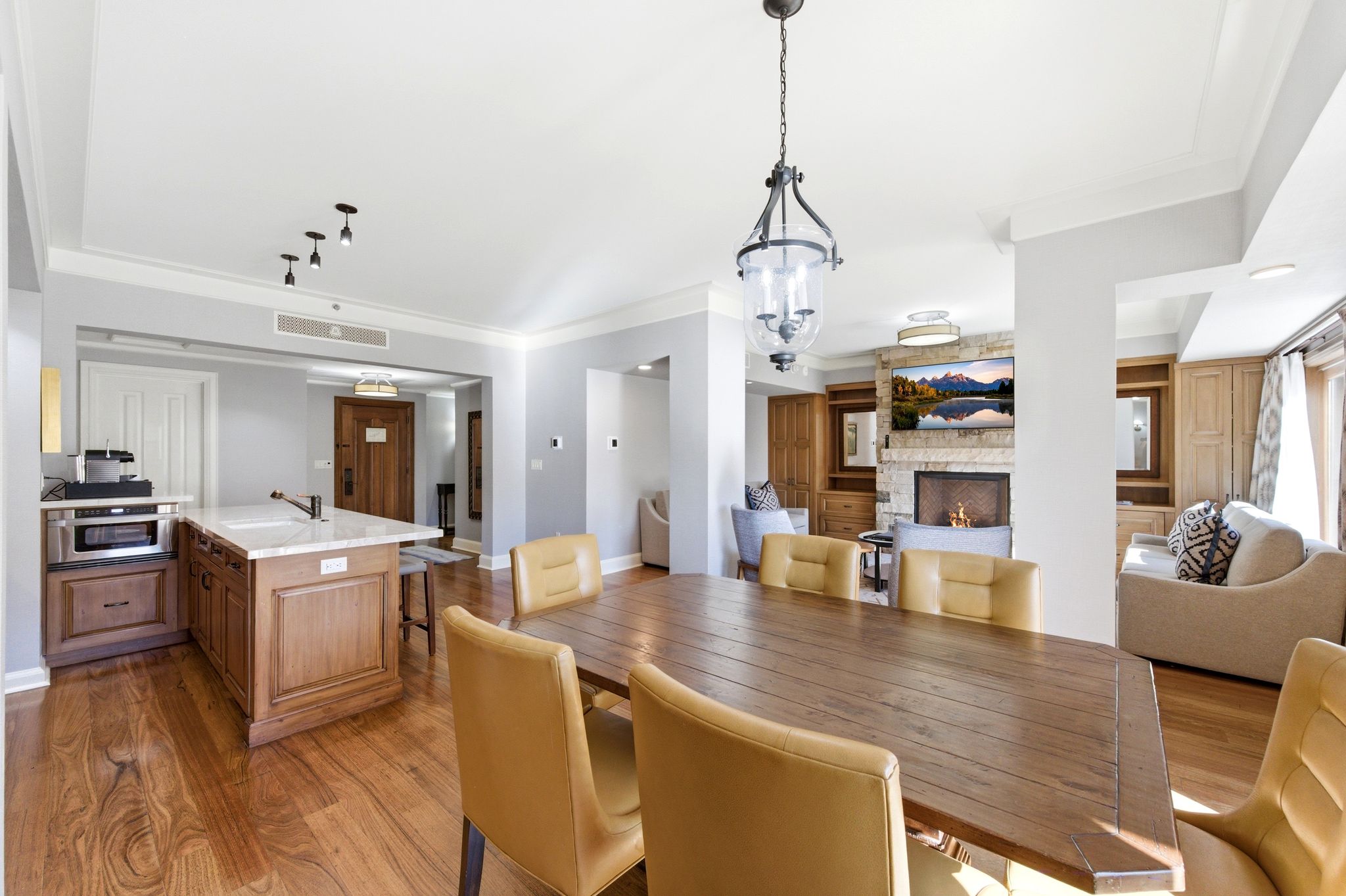 Open-concept dining area featuring wood-finish flooring and a central chandelier