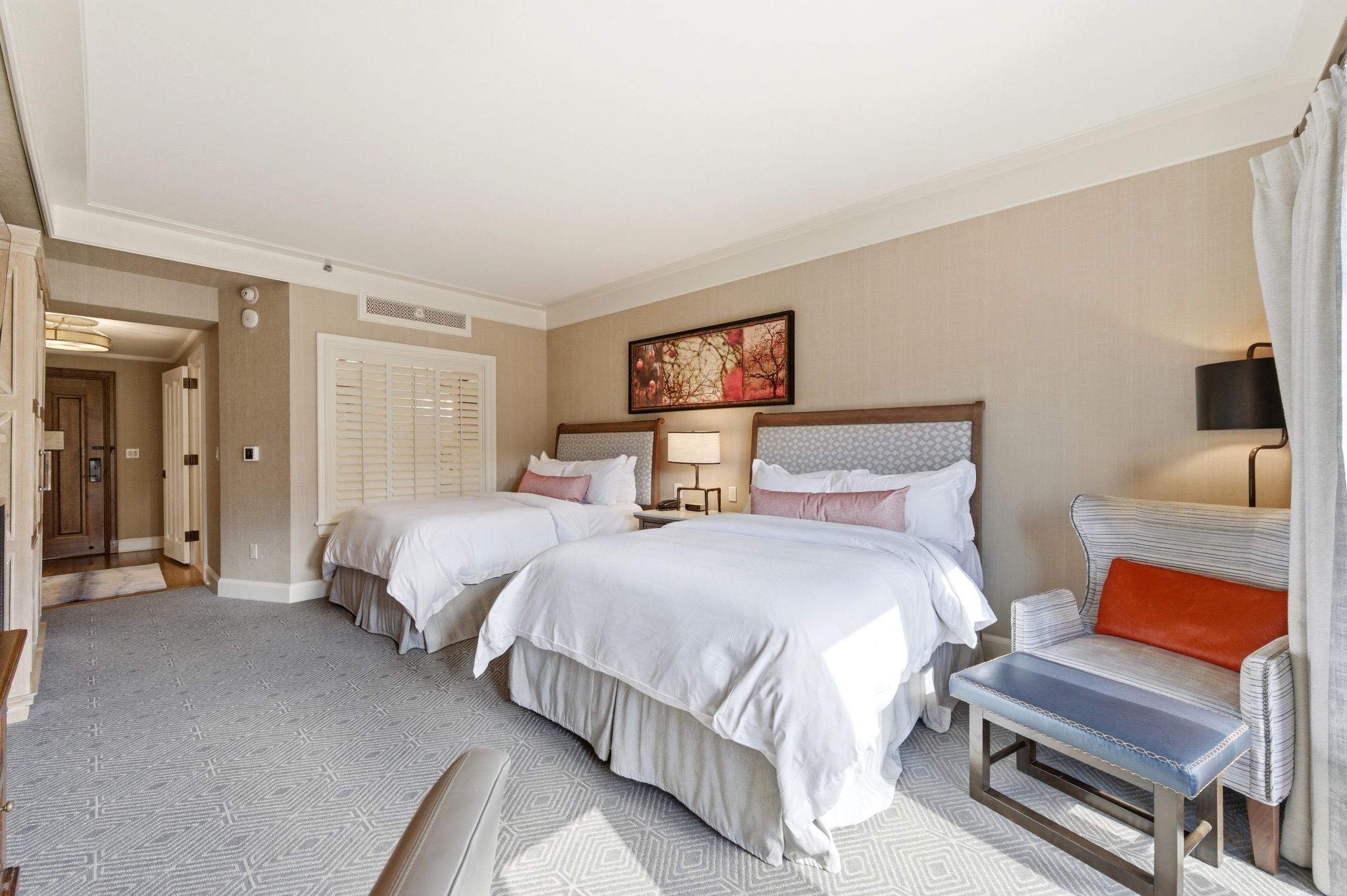Carpeted room featuring two beds with patterned headboards and recessed lighting