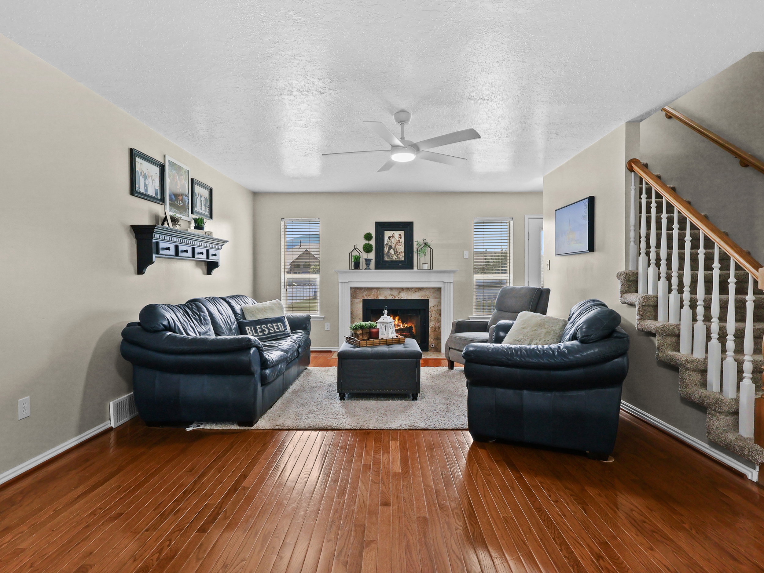 Spacious living area featuring rich wood-finish flooring and light-toned wall paint