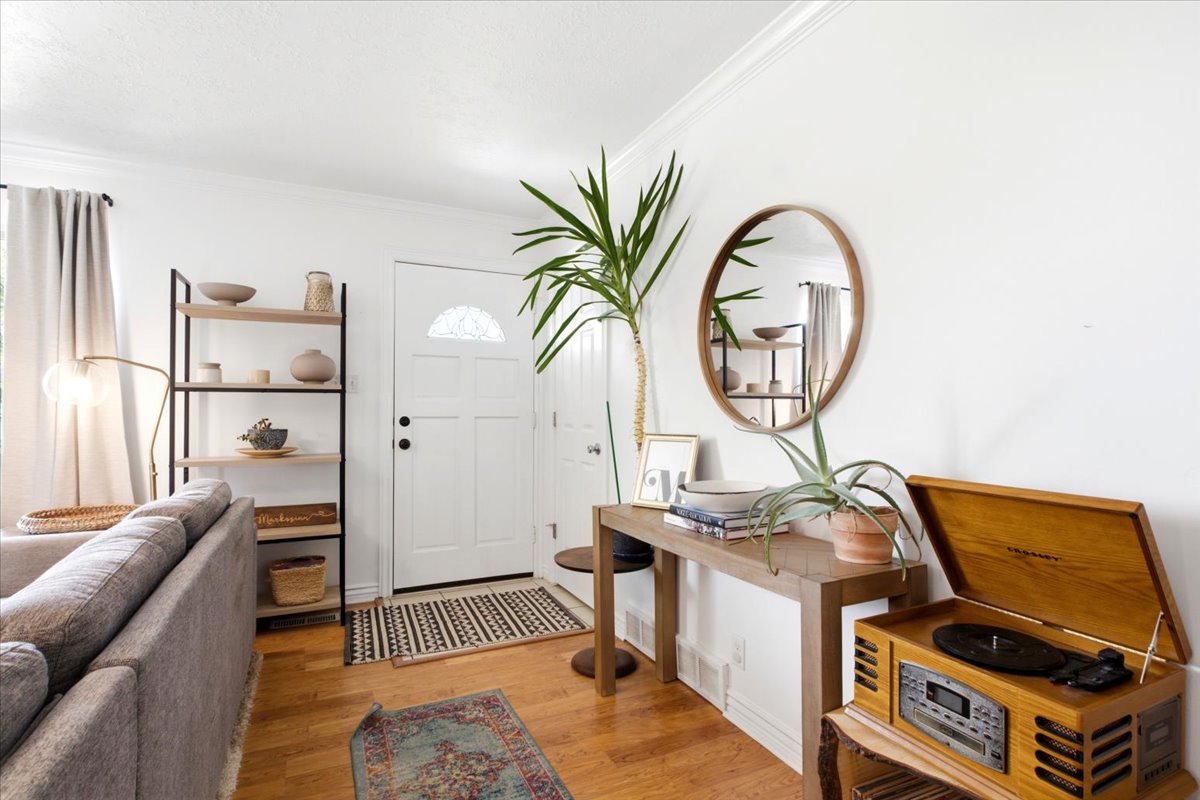 Entryway featuring a paneled door with decorative glass, wood-finish flooring, and white baseboards