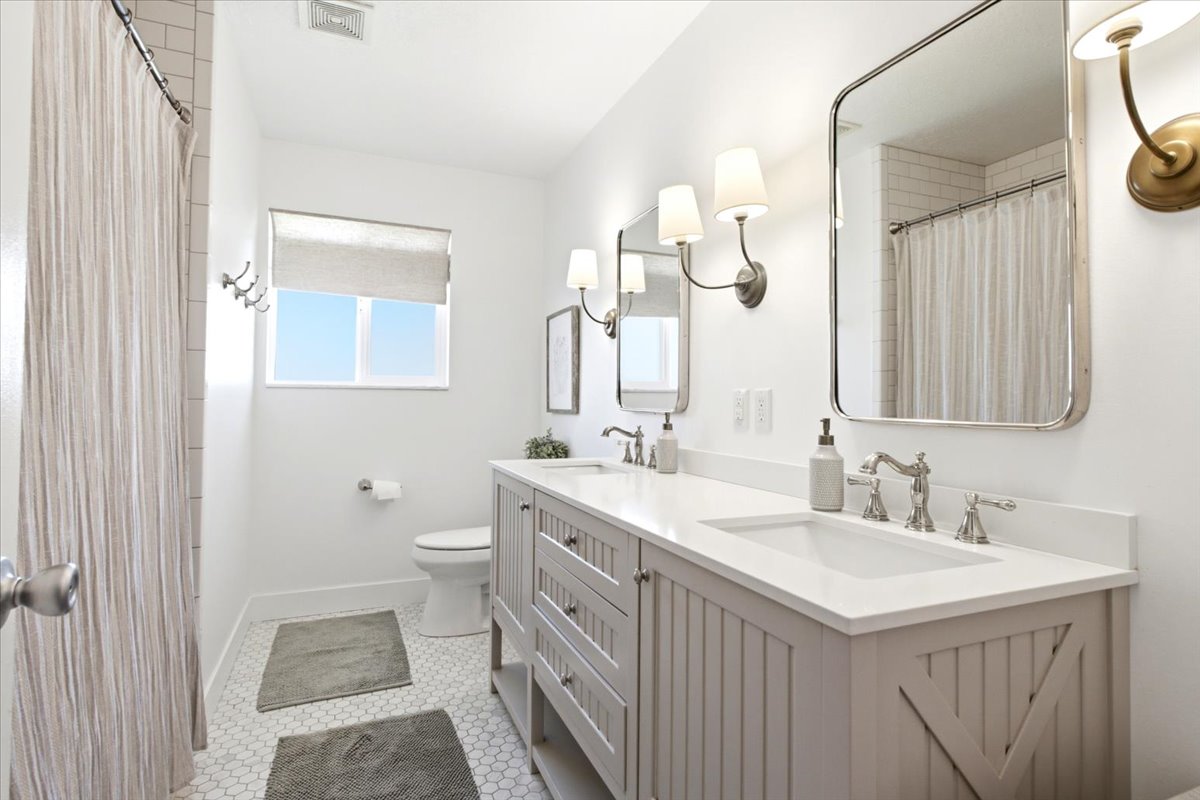 Double vanity featuring white countertops, undermount sinks, and brushed nickel fixtures