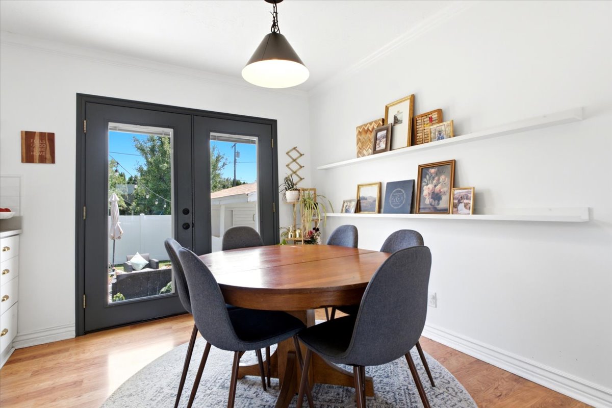 Dining area featuring wood-finish flooring, white walls, and crown molding