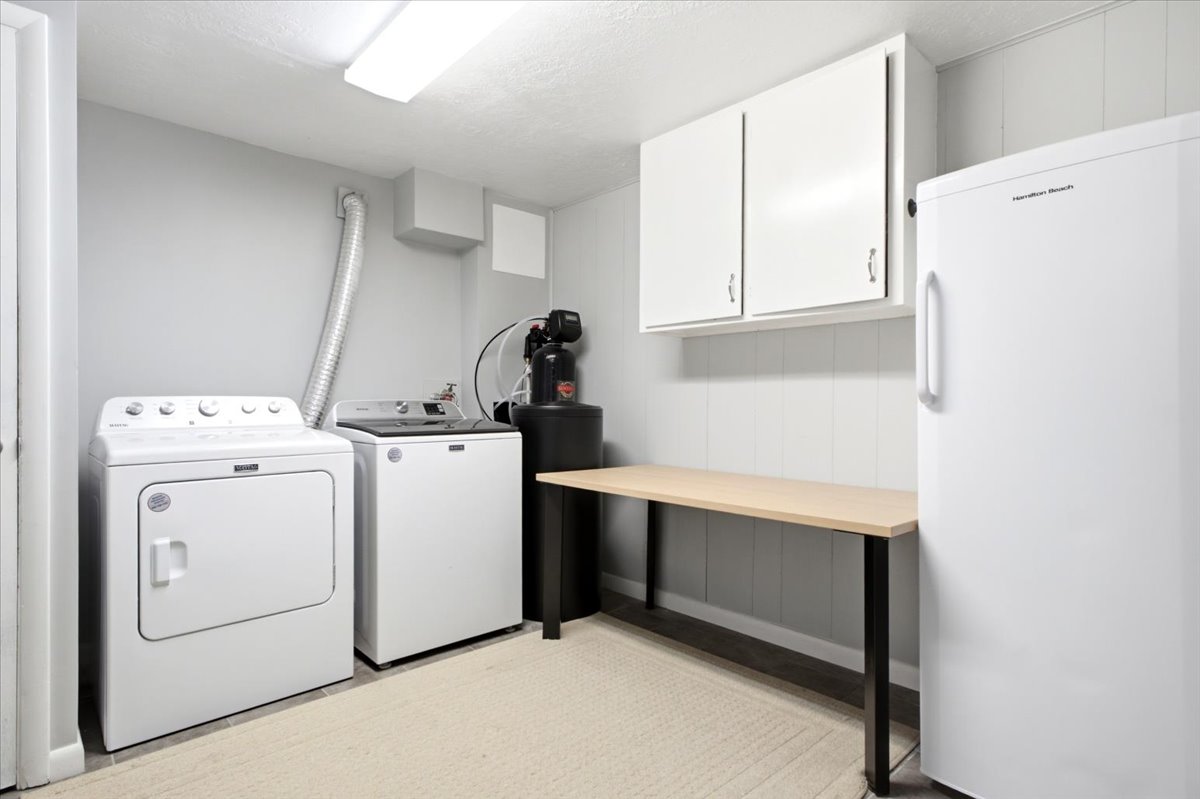Dedicated utility space featuring washer and dryer, built-in cabinetry, and a countertop workspace