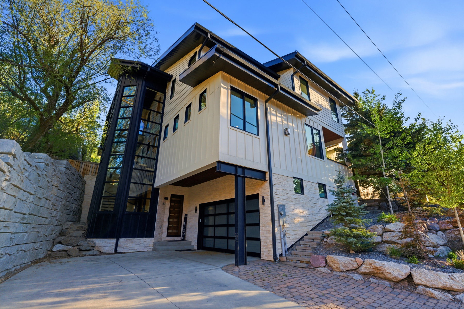 Contemporary multi-level residence featuring a striking glass-encased exterior staircase