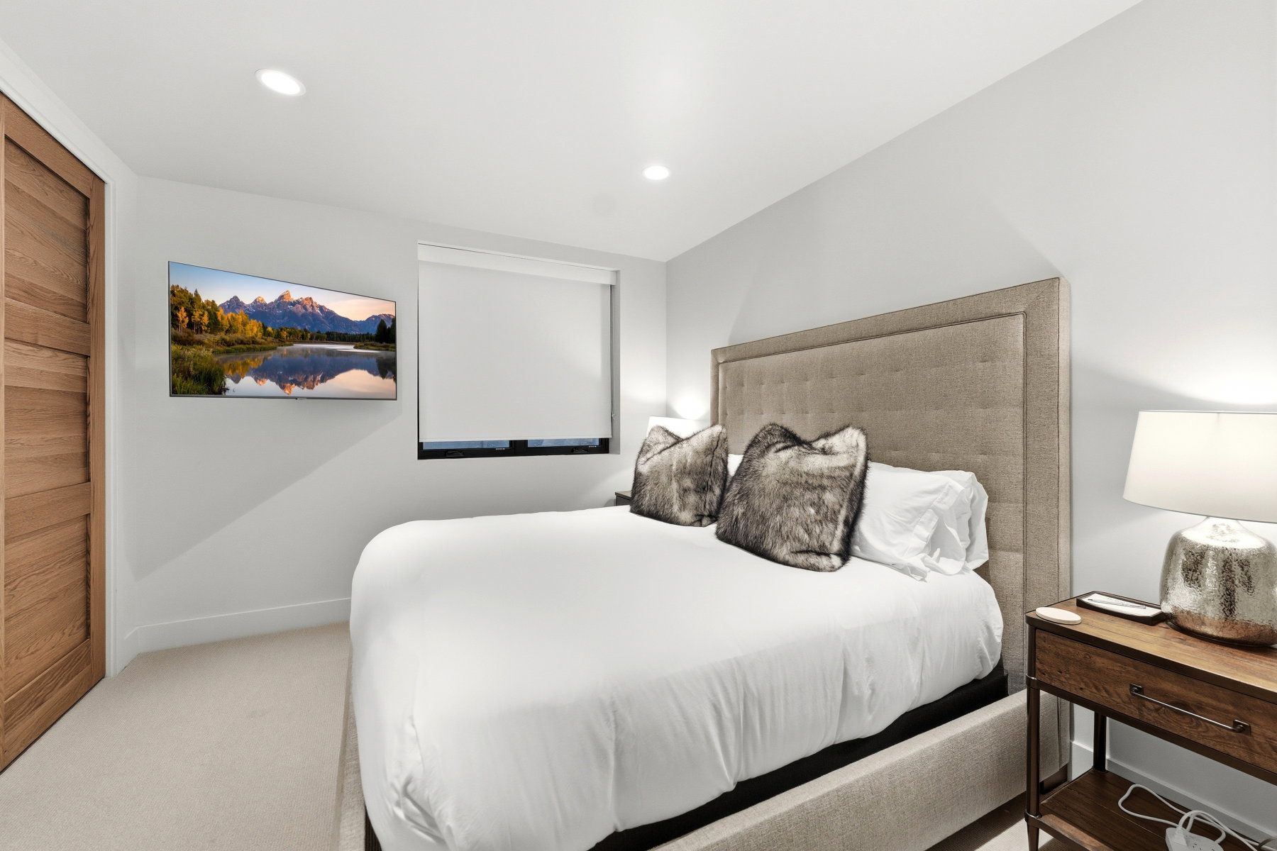 Bedroom featuring recessed lighting, light-toned carpeting, a window with roller shades, and a wall-mounted flat-screen television