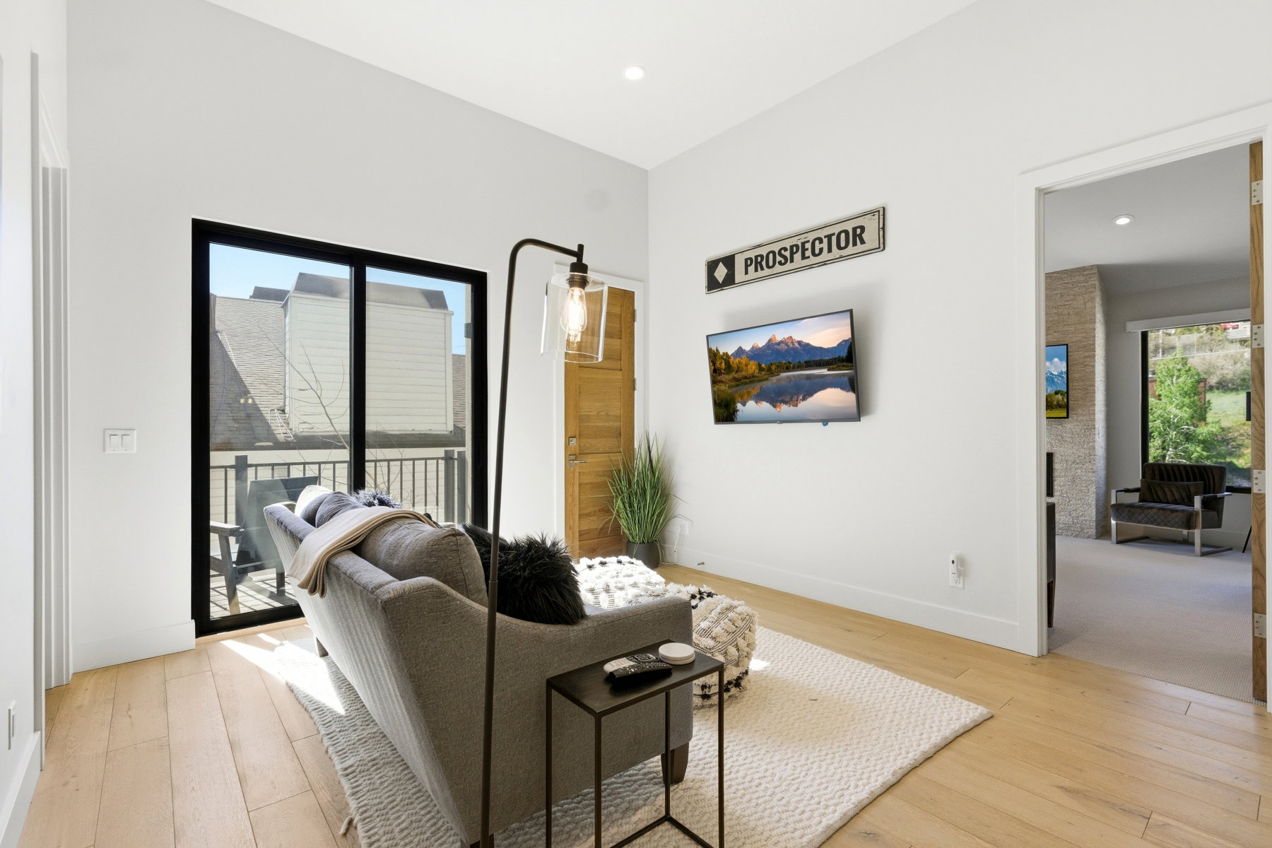 Living area featuring light wood-finish flooring, white walls, and recessed lighting