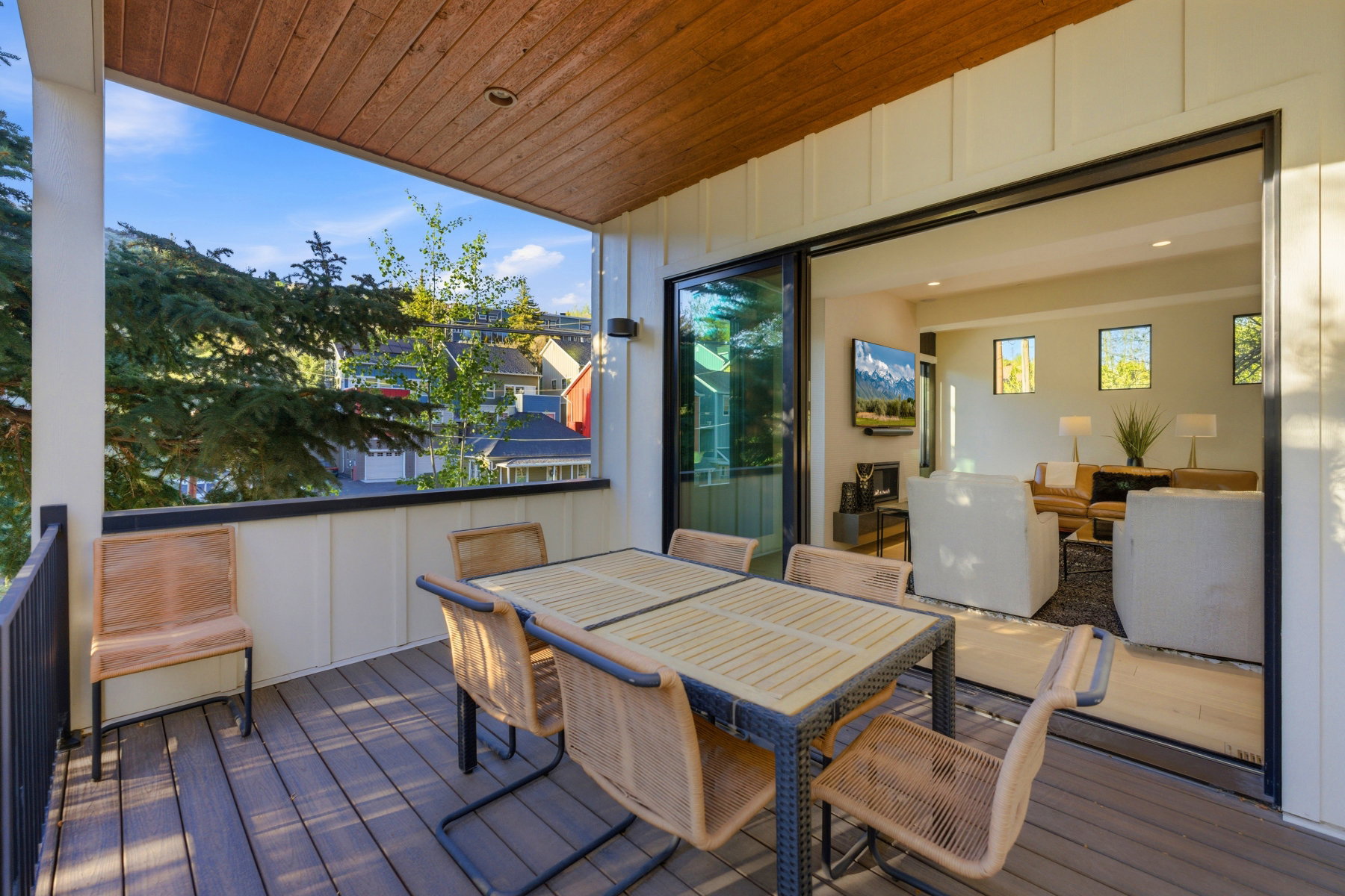 Covered outdoor deck featuring composite decking and a natural wood-finish ceiling
