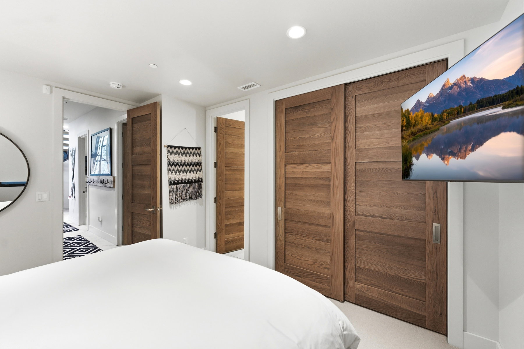 Wood-finish sliding closet doors with recessed pulls and flush paneling