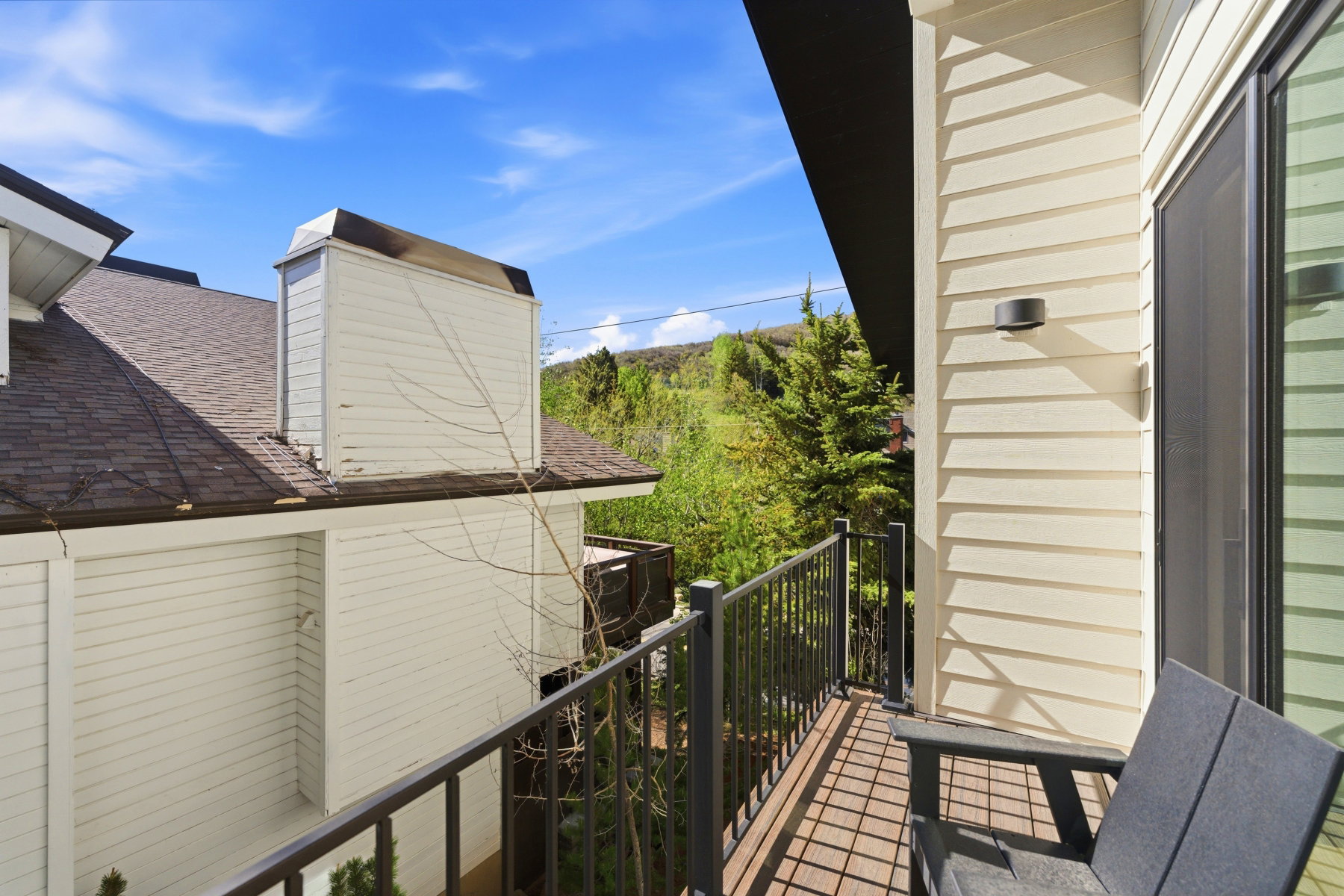 Outdoor balcony featuring wood-finish flooring and black metal railings