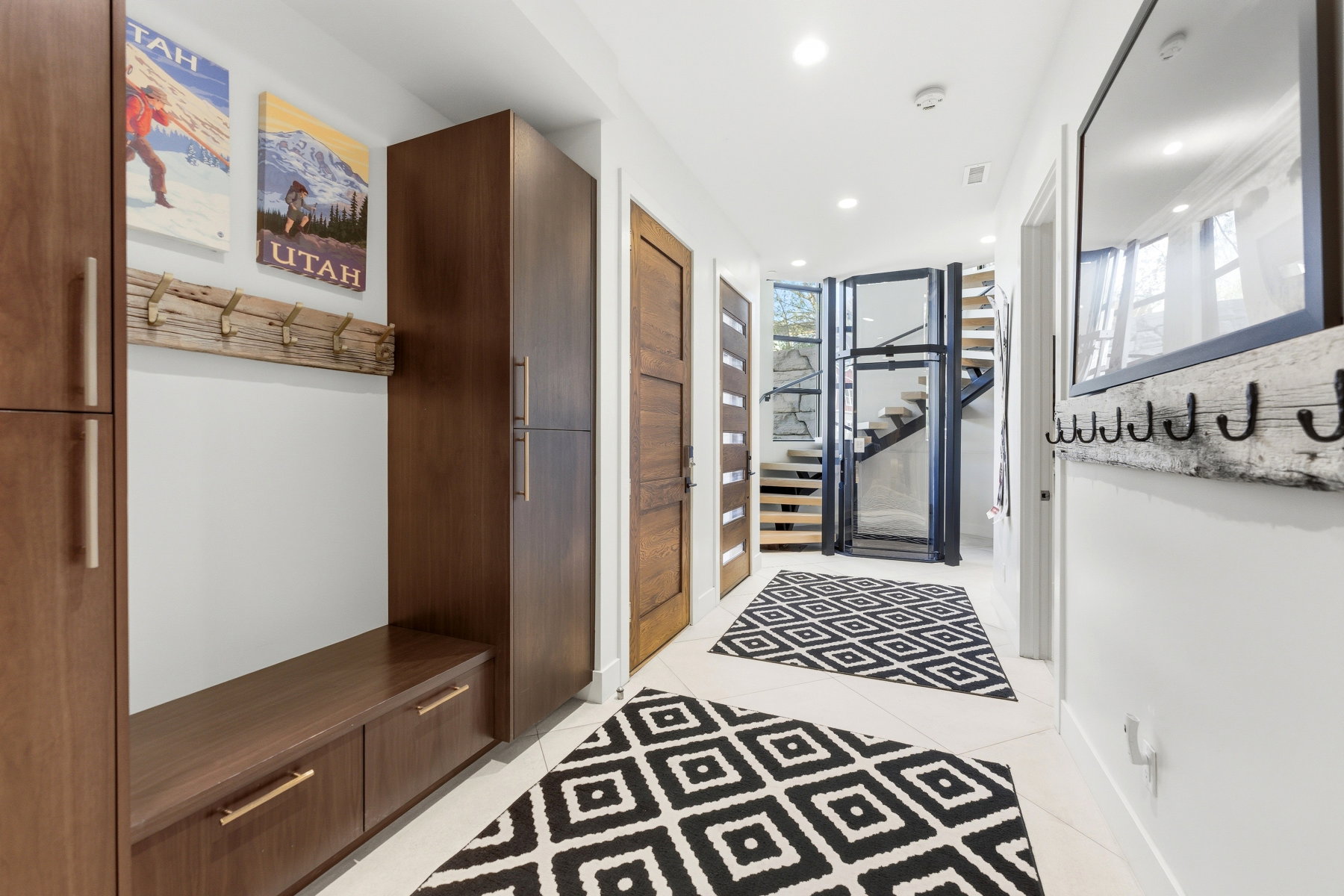 Hallway featuring light tile flooring, recessed lighting, wood-finish built-in cabinetry, and a private elevator