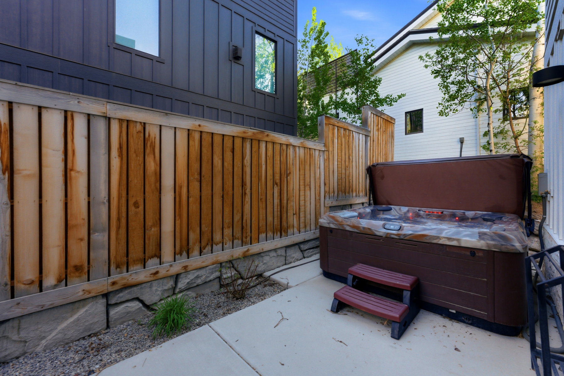 Private outdoor spa area featuring a built-in hot tub with a protective cover