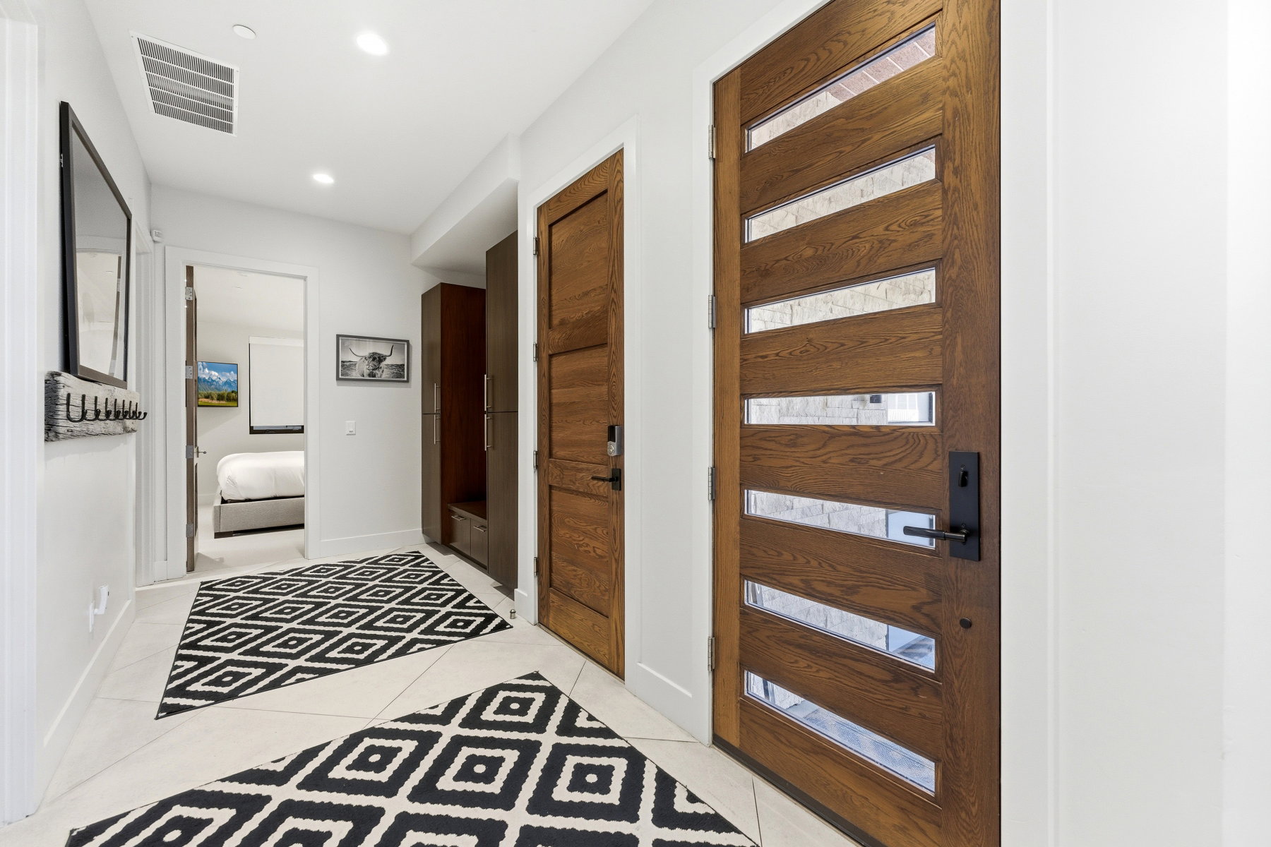 Entryway featuring a modern wood-finish door with frosted glass panels and matte black hardware