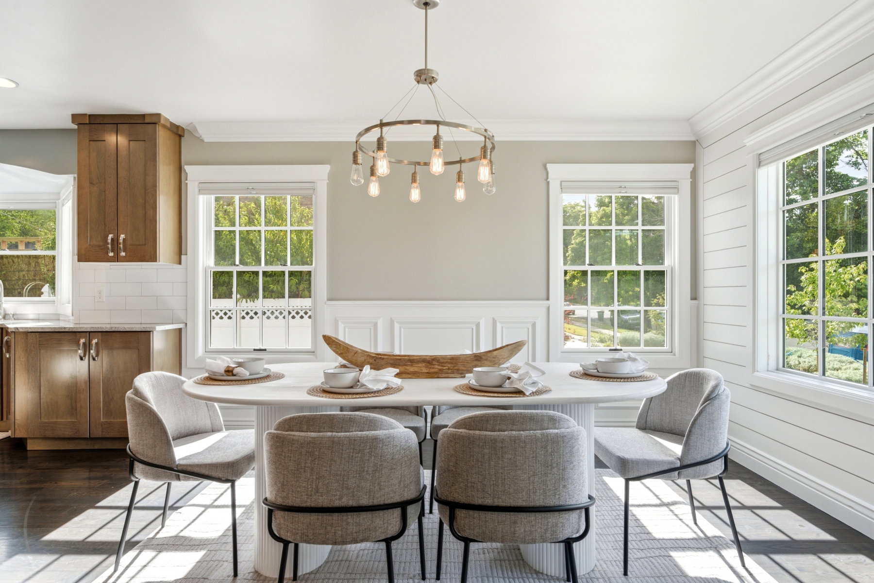 Dining area with a modern chandelier and wainscoting