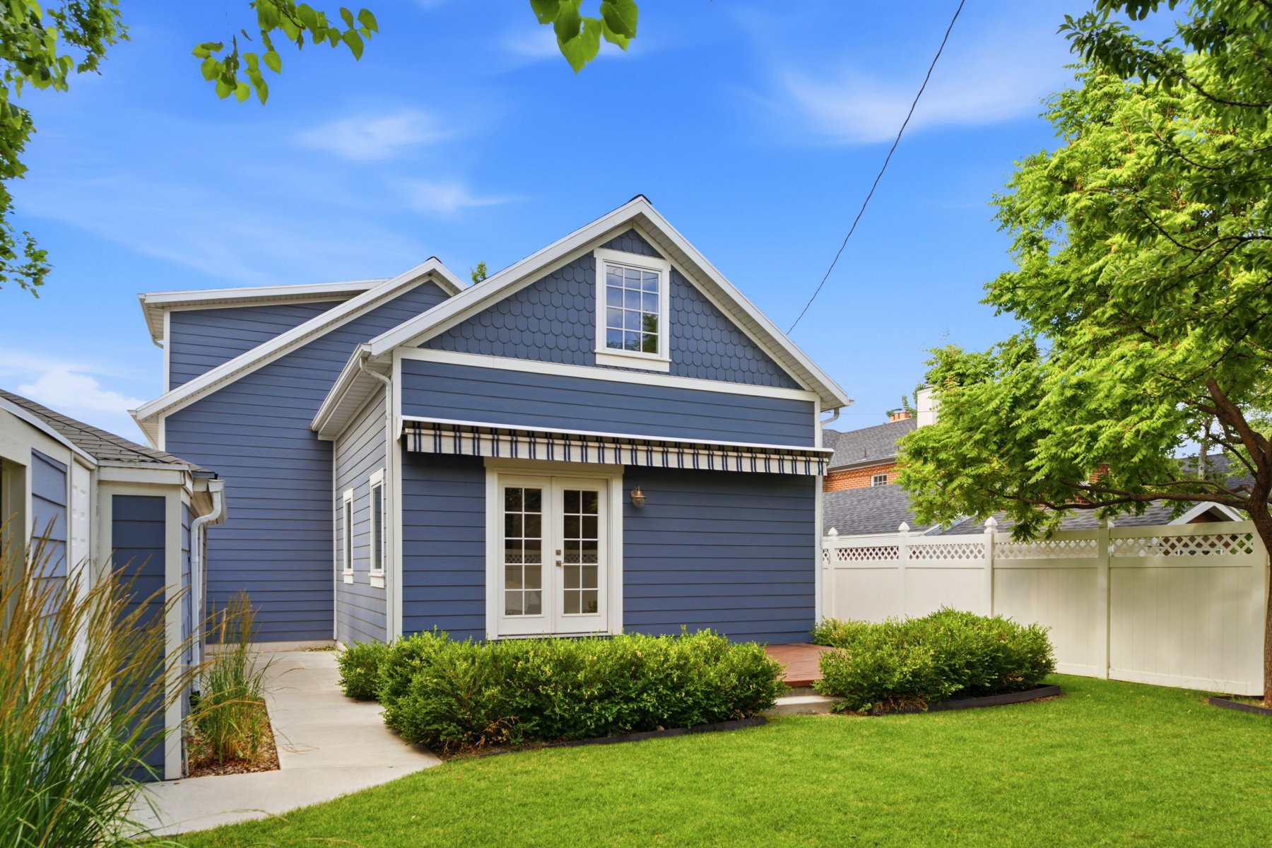 Exterior featuring blue horizontal siding, white trim, and a gabled roof