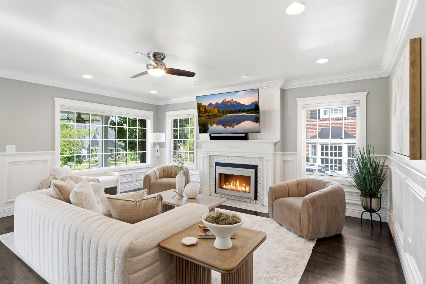 Living room featuring a tiled fireplace with a modern insert, dark wood-finish flooring, and crown molding