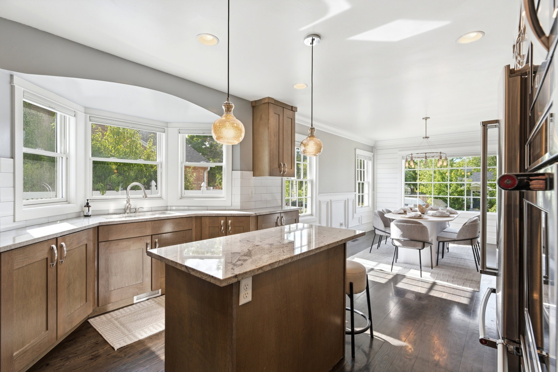 Spacious kitchen and dining area featuring dark wood-finish flooring