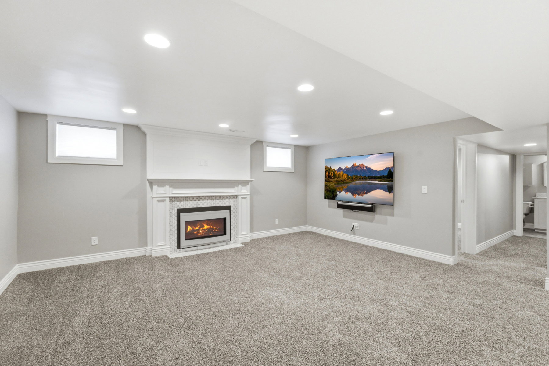 Spacious living area featuring a built-in fireplace with an ornate mantel and tile surround, recessed lighting, neutral carpeting, and white trim